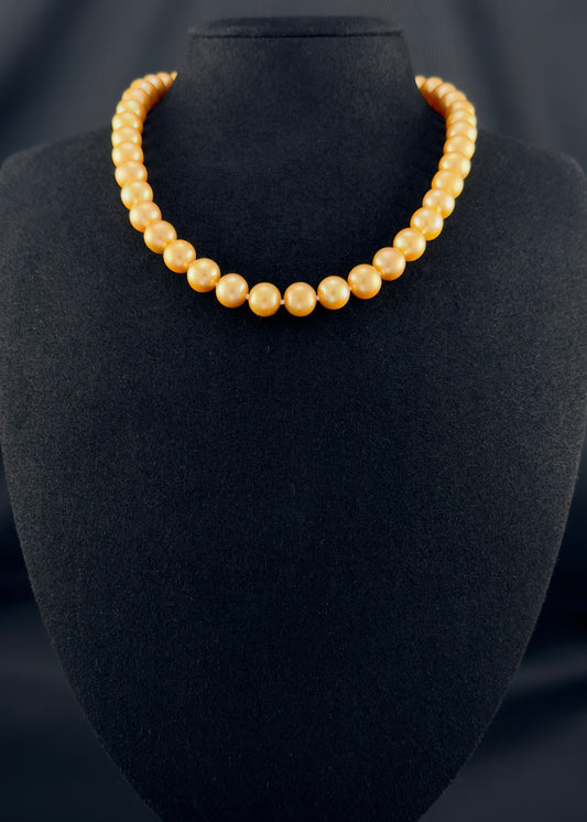 Cultured, South Sea deep-gold pearl necklace, exhibited on black suede, excellent reflection, 9-10mm, 16", yellow gold clasp.