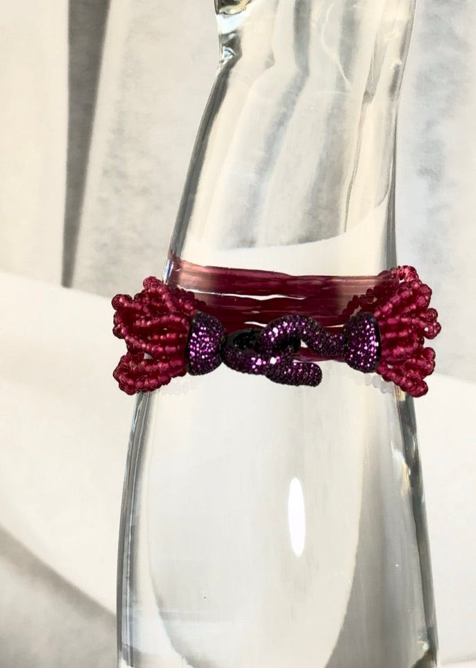 White background, clear glass display, magenta crystal beads, pink hook clasp