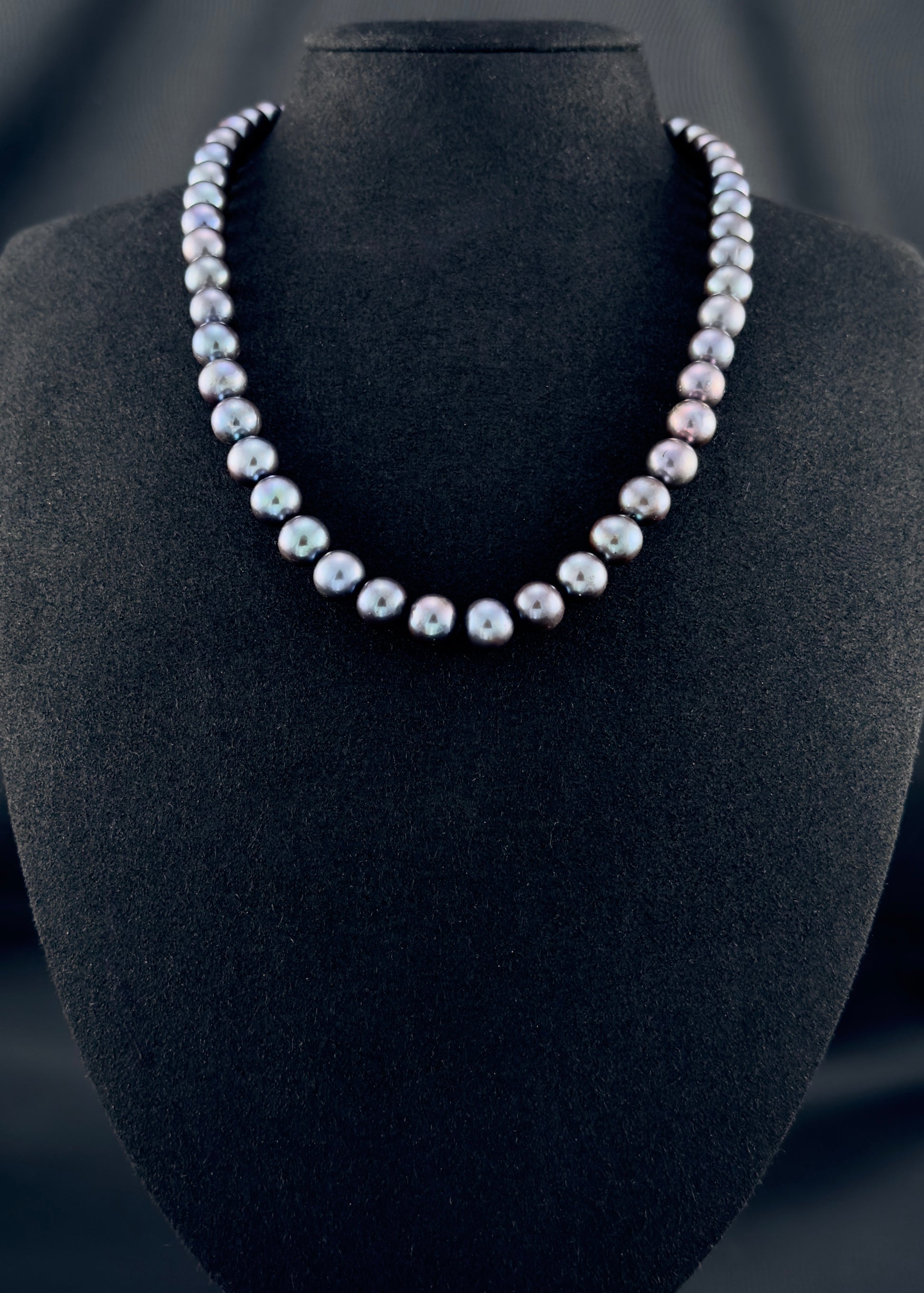 Cultured, Tahitian black-red pearl necklace, exhibited on black suede, excellent reflection, 9-10mm, 18", yellow gold clasp.