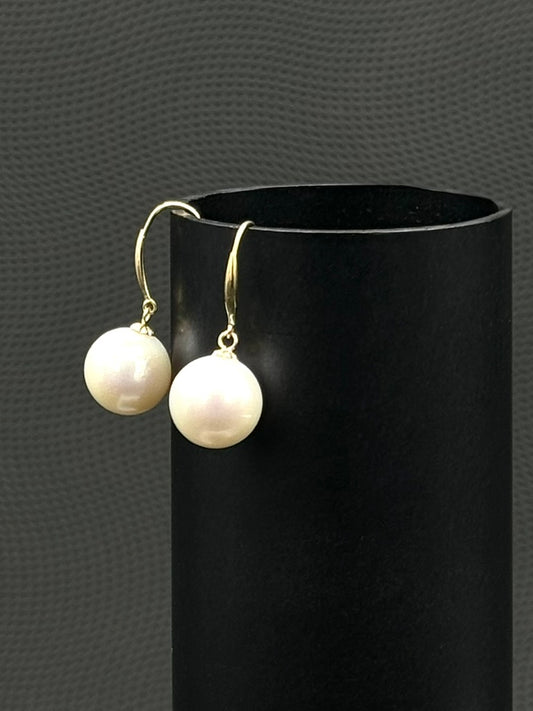 Cultured, South Sea, pearl earrings, exhibited on black cylinder, drop style, white, sound reflection, 10-11mm, 18k yellow gold.