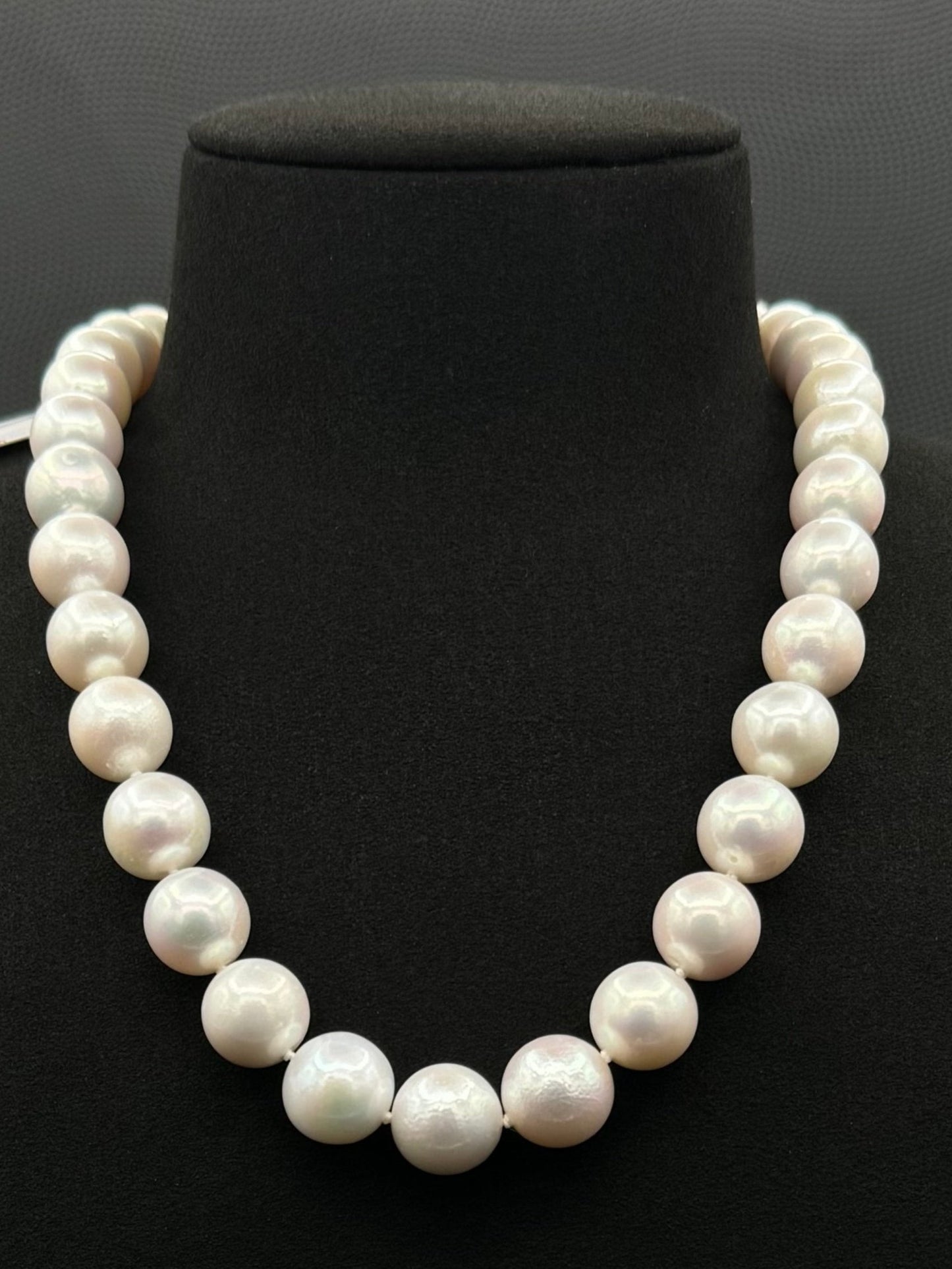 Cultured, South Sea white pearl strand necklace, exhibited on black suede, excellent reflection, 13-14.5mm, 18", white gold clasp.