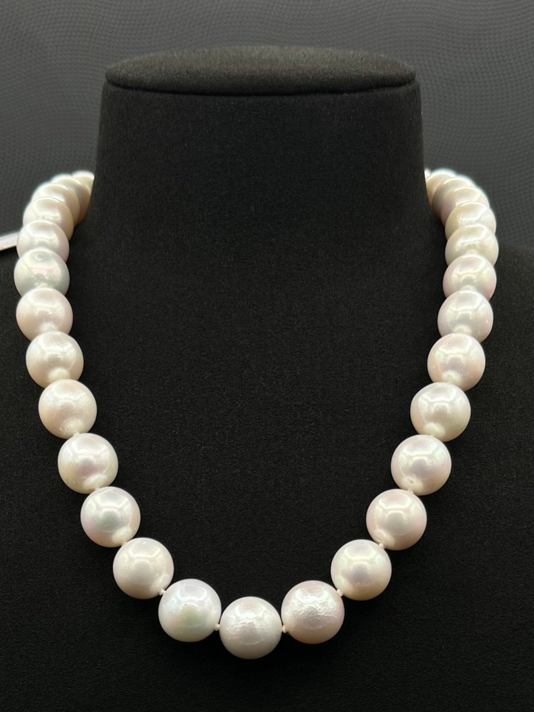 Cultured, South Sea white pearl strand necklace, exhibited on black suede, excellent reflection, 13-14.5mm, 18", white gold clasp.
