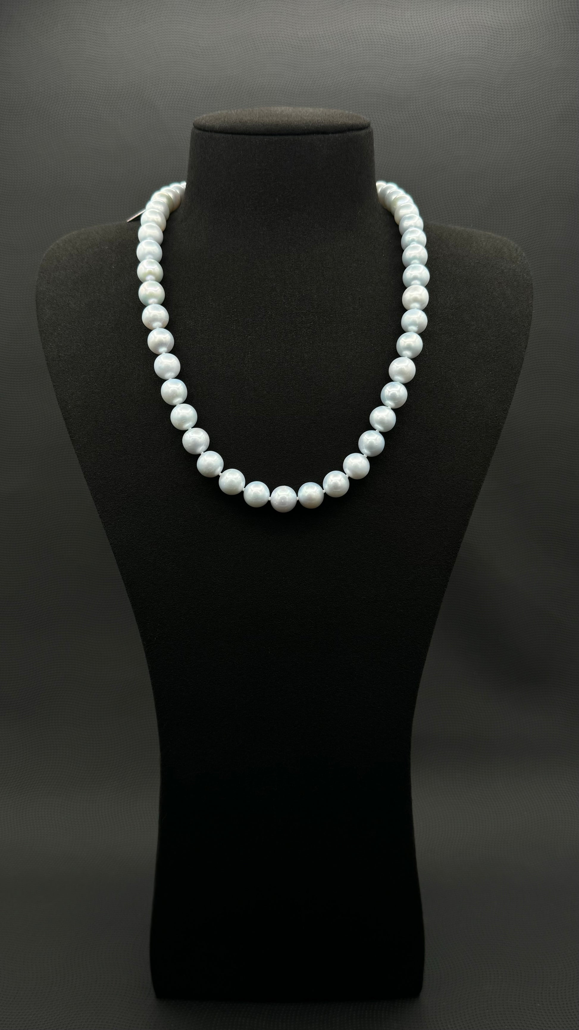 Cultured, South Sea blue pearl strand necklace, exhibited on black suede, excellent reflection, 10mm, 20", white gold clasp.