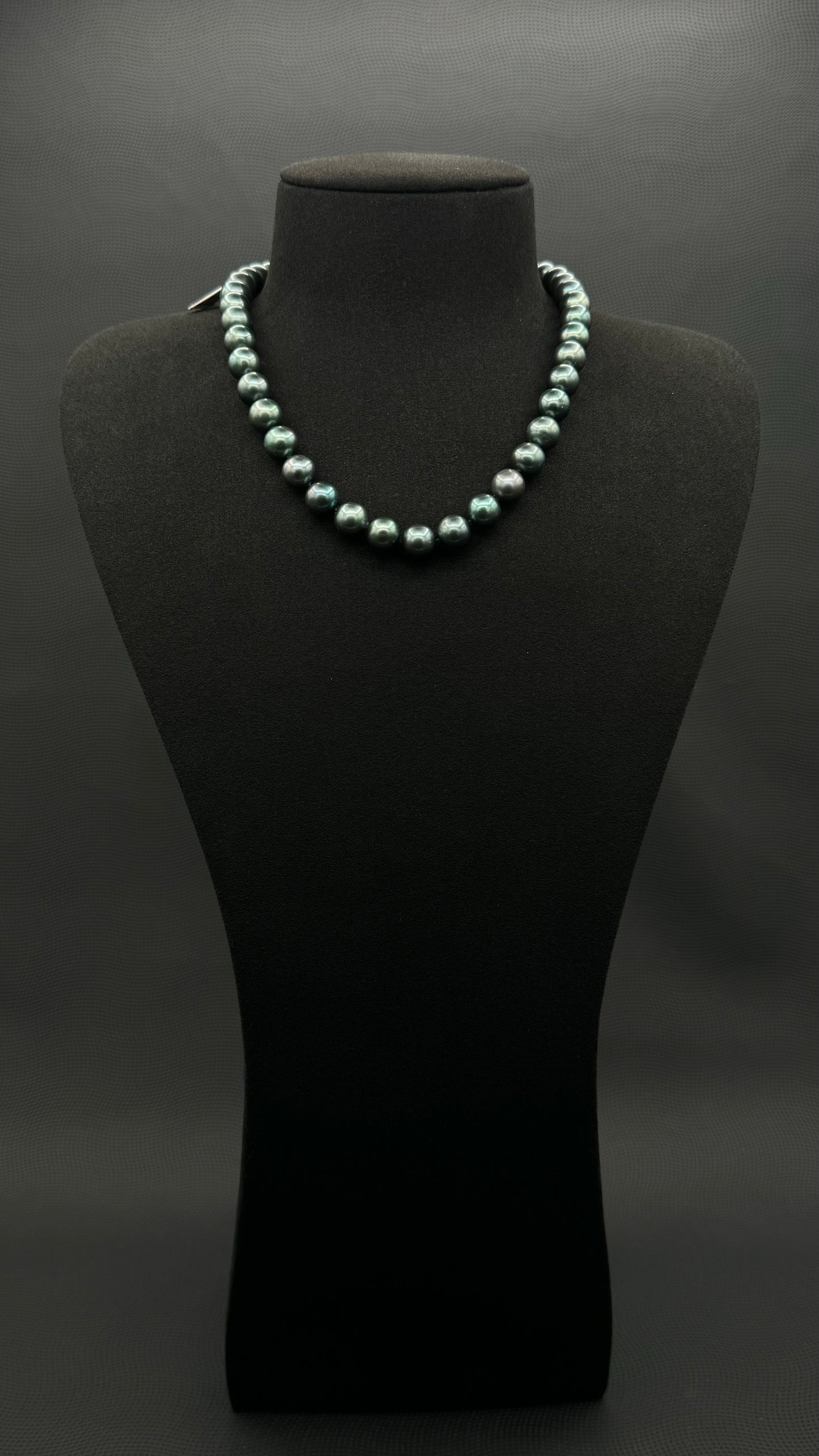 Cultured, Tahitian, green pearl strand necklace, exhibited on black suede, sound reflection, 9-9.5mm, 16", yellow gold clasp.