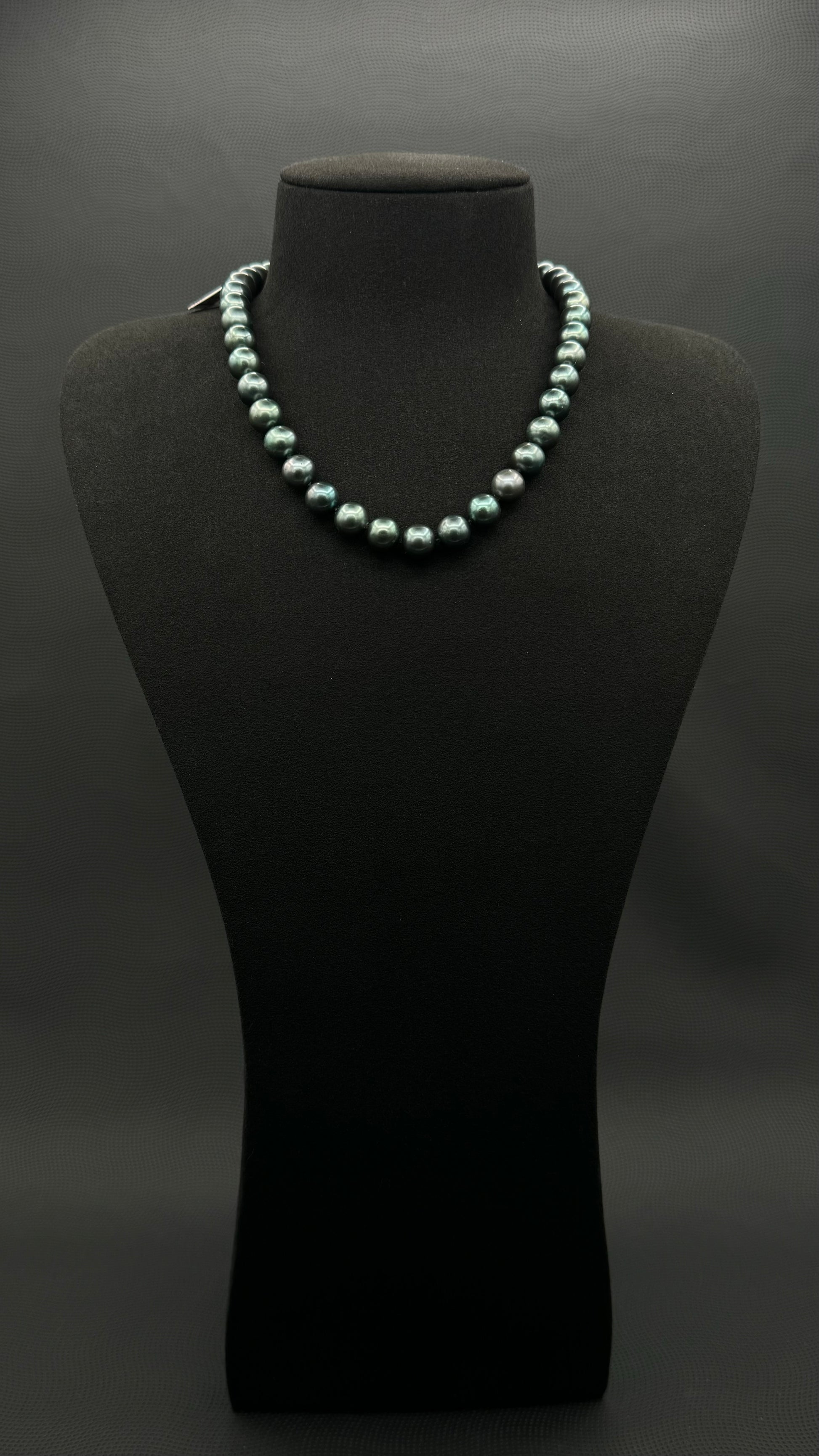 Cultured, Tahitian, green pearl strand necklace, exhibited on black suede, sound reflection, 9-9.5mm, 16", yellow gold clasp.