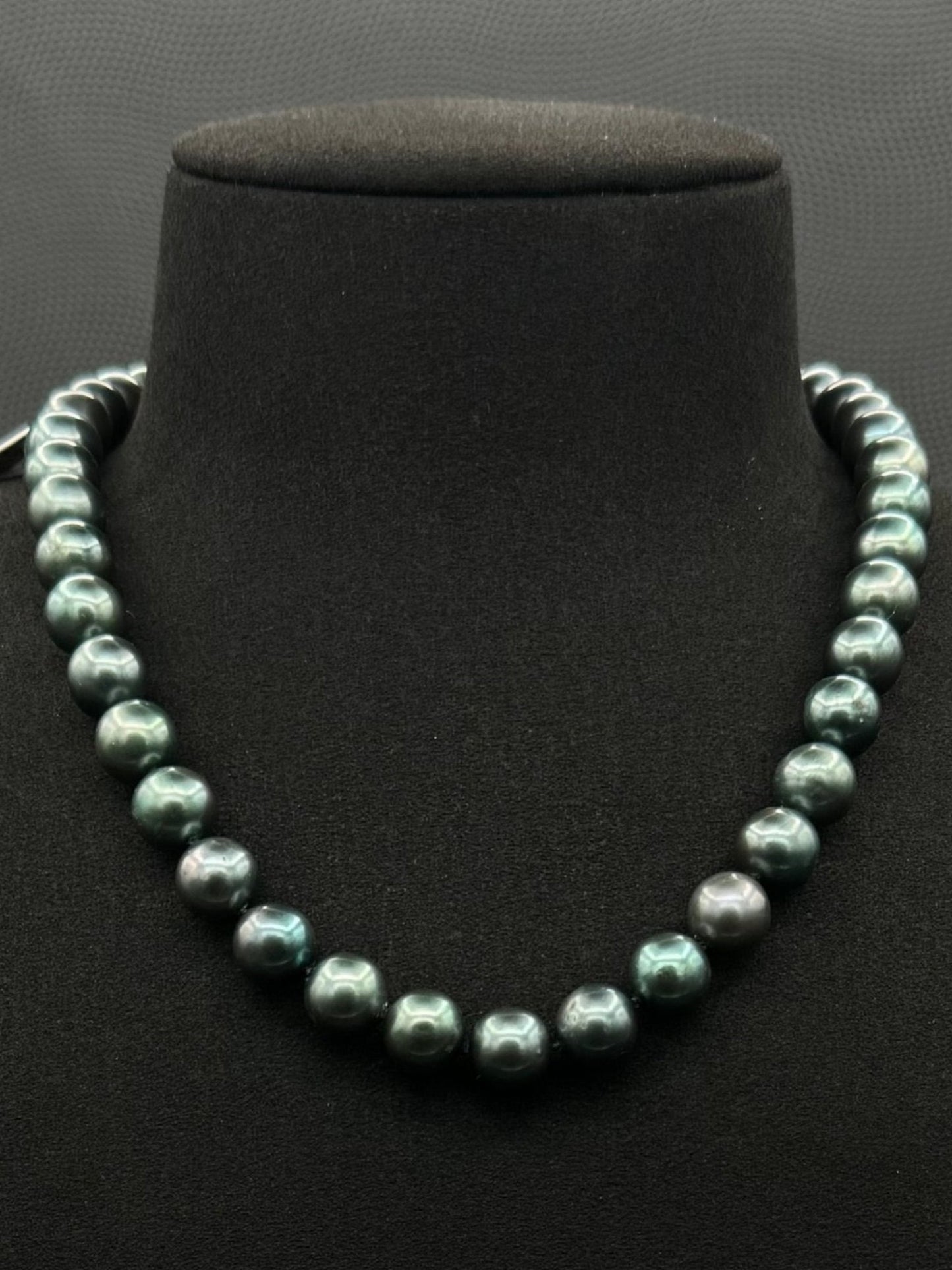 Cultured, Tahitian, green pearl strand necklace, exhibited on black suede, sound reflection, 9-9.5mm, 16", yellow gold clasp.
