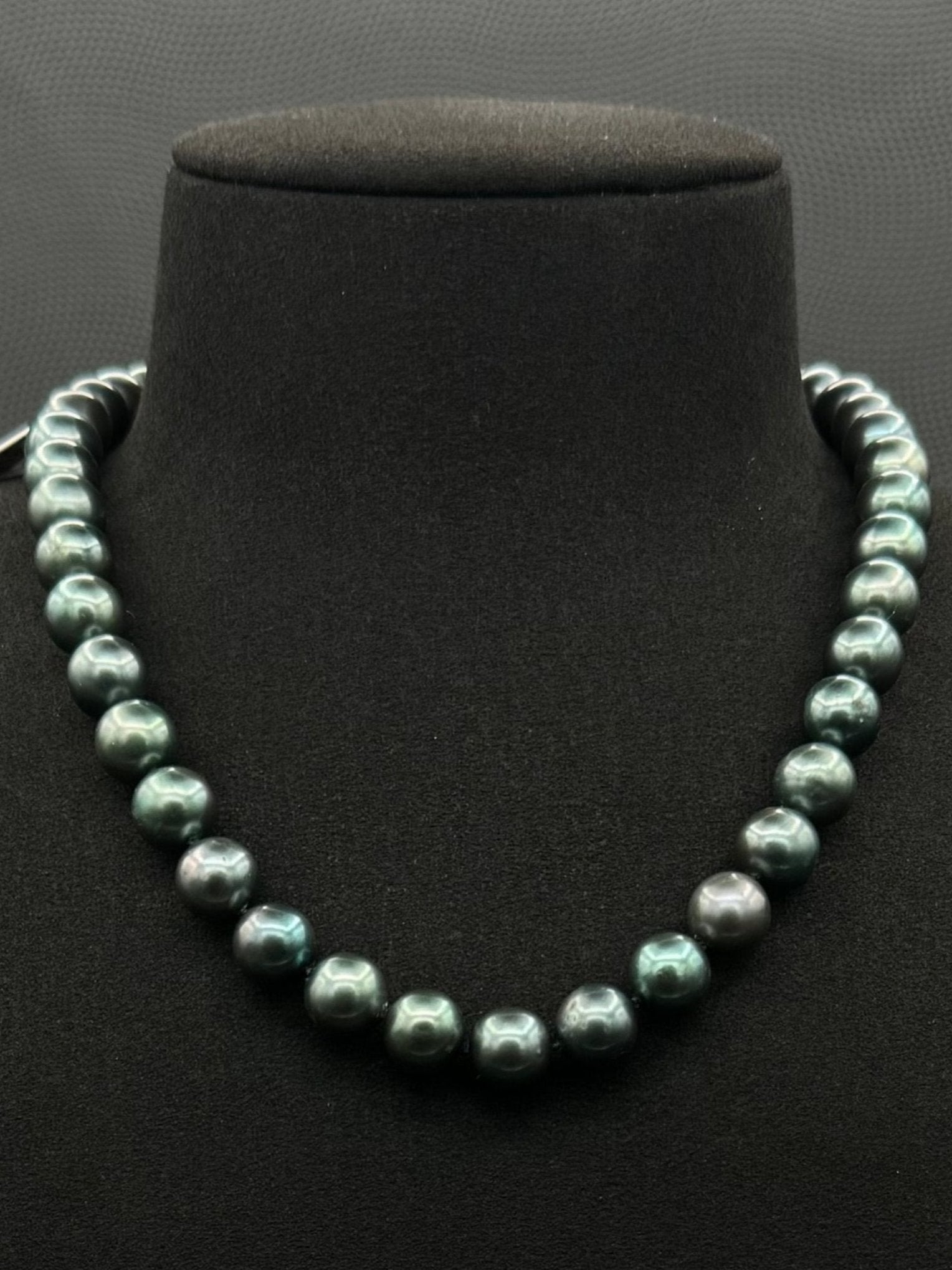 Cultured, Tahitian, green pearl strand necklace, exhibited on black suede, sound reflection, 9-9.5mm, 16", yellow gold clasp.