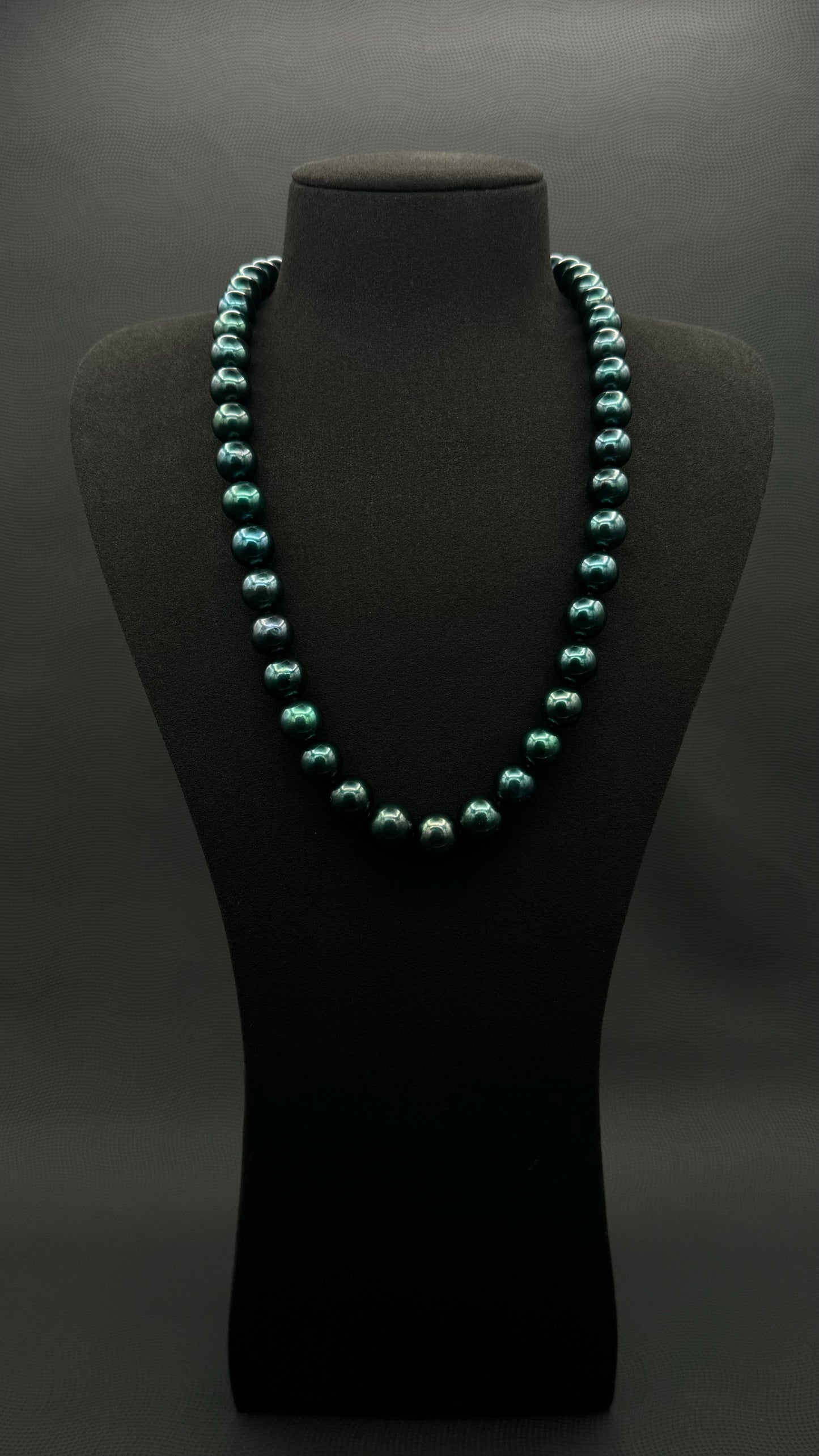 Cultured, Tahitian, dark green pearl continuous strand necklace, exhibited on black suede, excellent reflection, 11-12mm, 23", no clasp.
