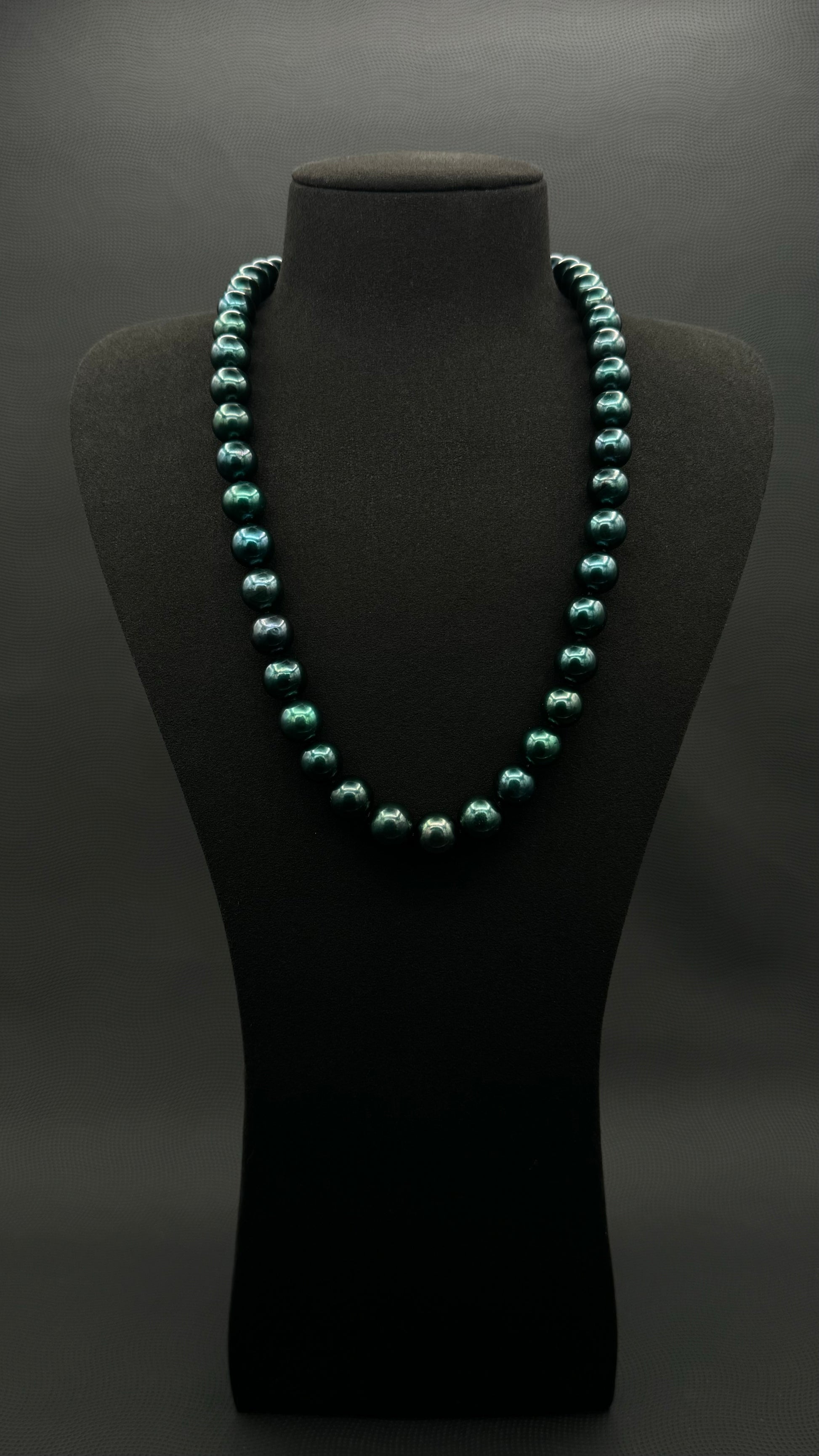 Cultured, Tahitian, dark green pearl continuous strand necklace, exhibited on black suede, excellent reflection, 11-12mm, 23", no clasp.