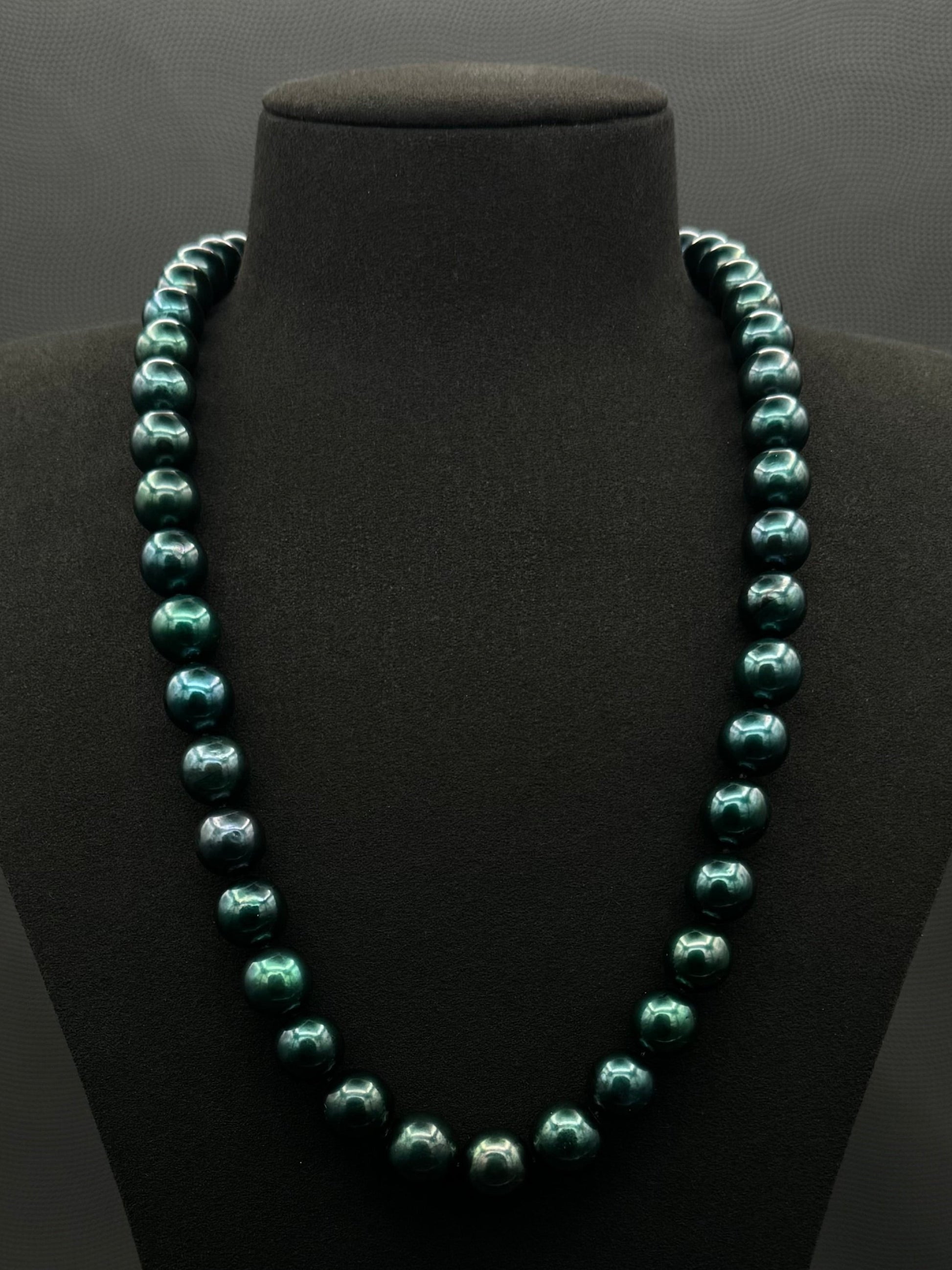 Cultured, Tahitian, dark green pearl continuous strand necklace, exhibited on black suede, excellent reflection, 11-12mm, 23", no clasp.