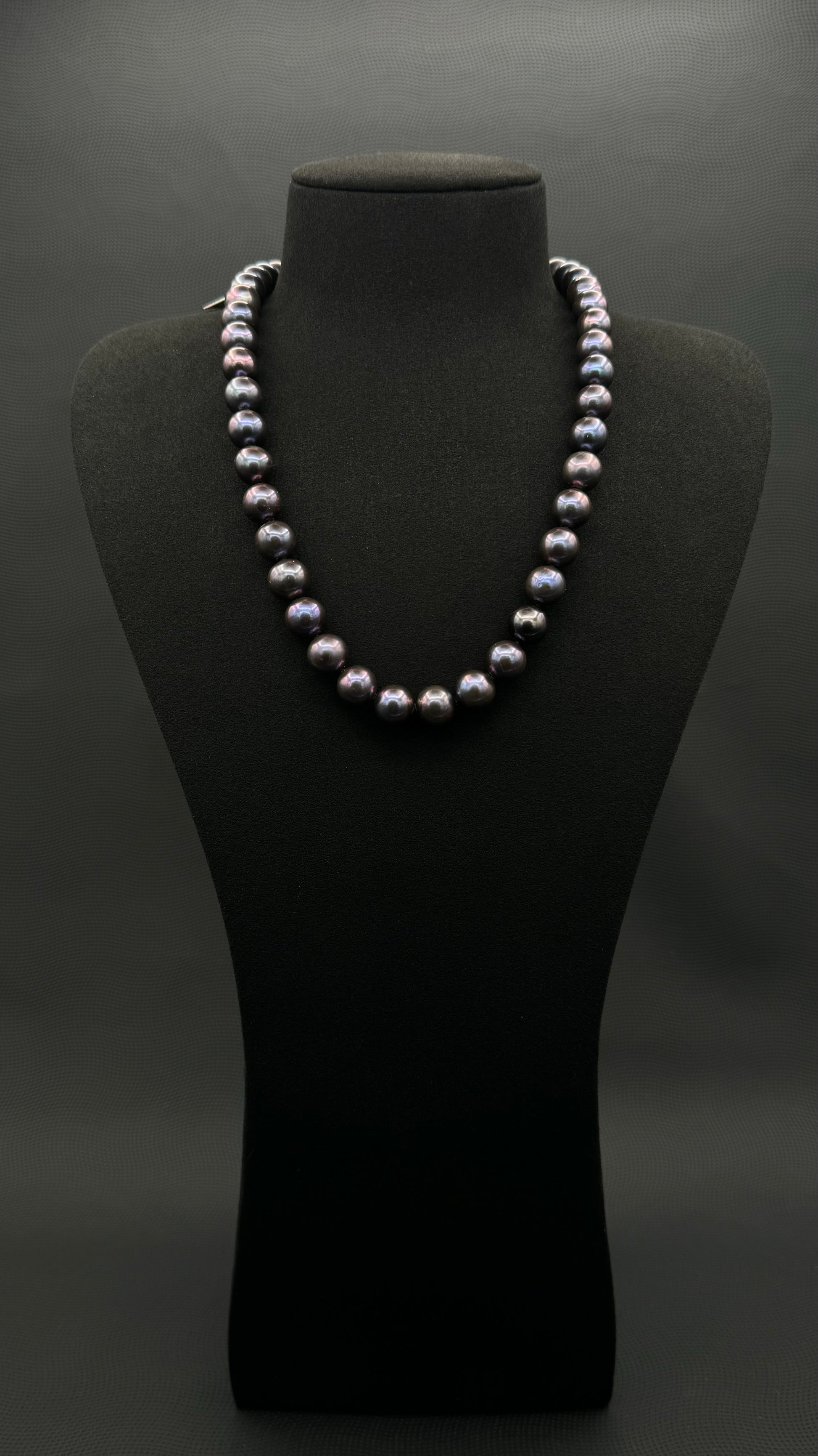 Cultured, Tahitian purple pearl strand necklace, exhibited on black suede, excellent reflection, 10.5-11.5mm, 20", white gold clasp.