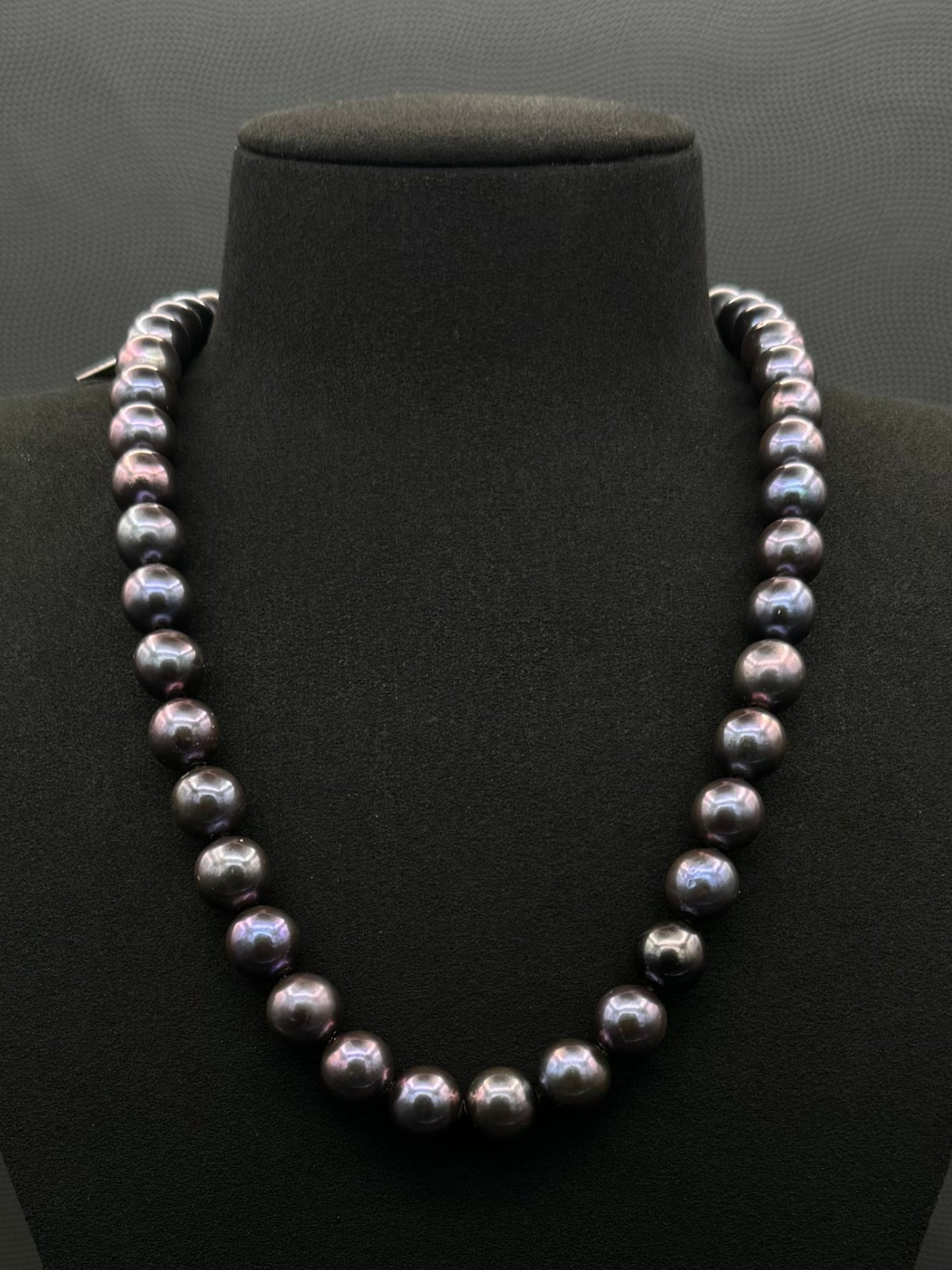 Cultured, Tahitian purple pearl strand necklace, exhibited on black suede, excellent reflection, 10.5-11.5mm, 20", white gold clasp.