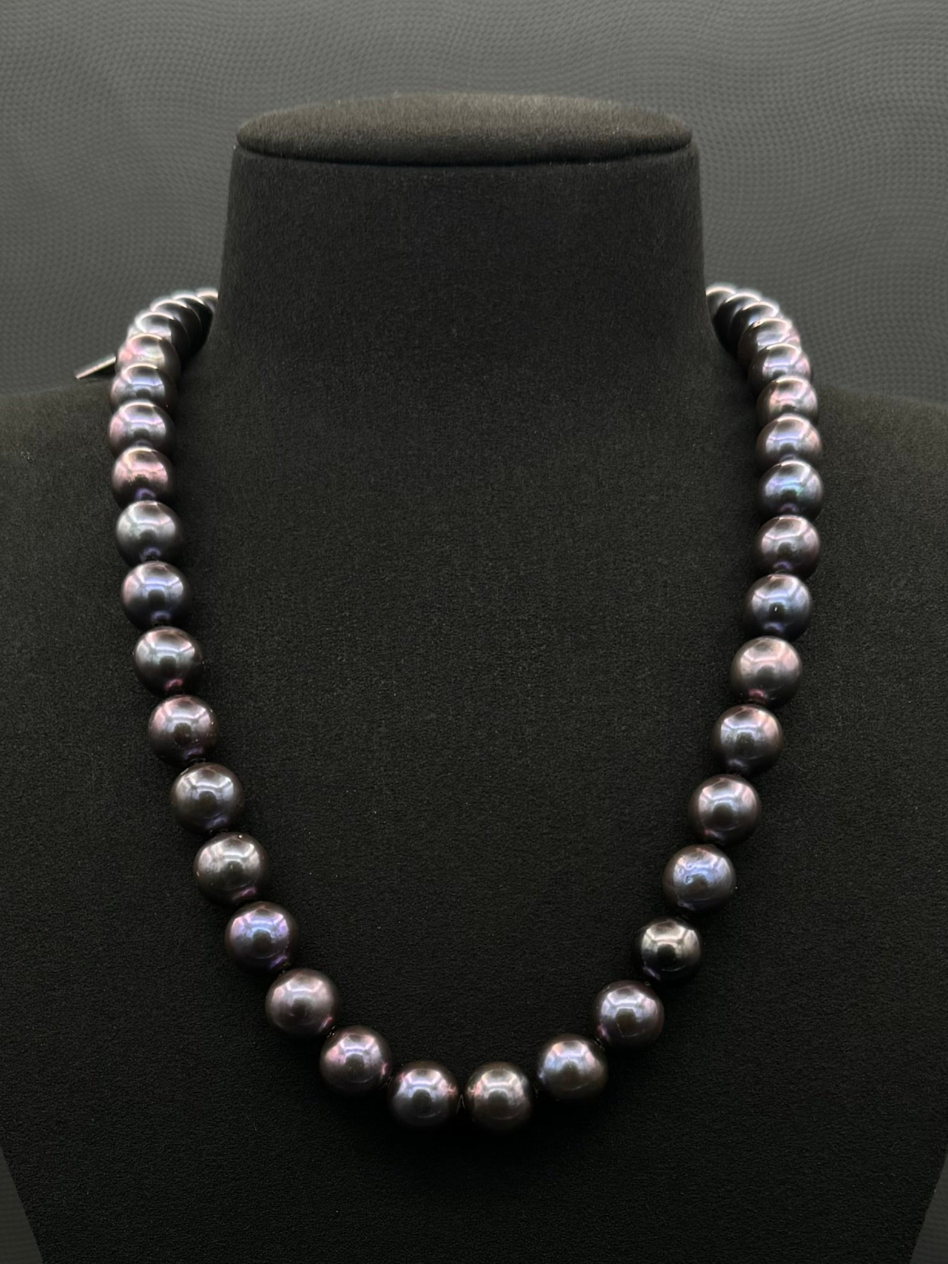 Cultured, Tahitian purple pearl strand necklace, exhibited on black suede, excellent reflection, 10.5-11.5mm, 20", white gold clasp.
