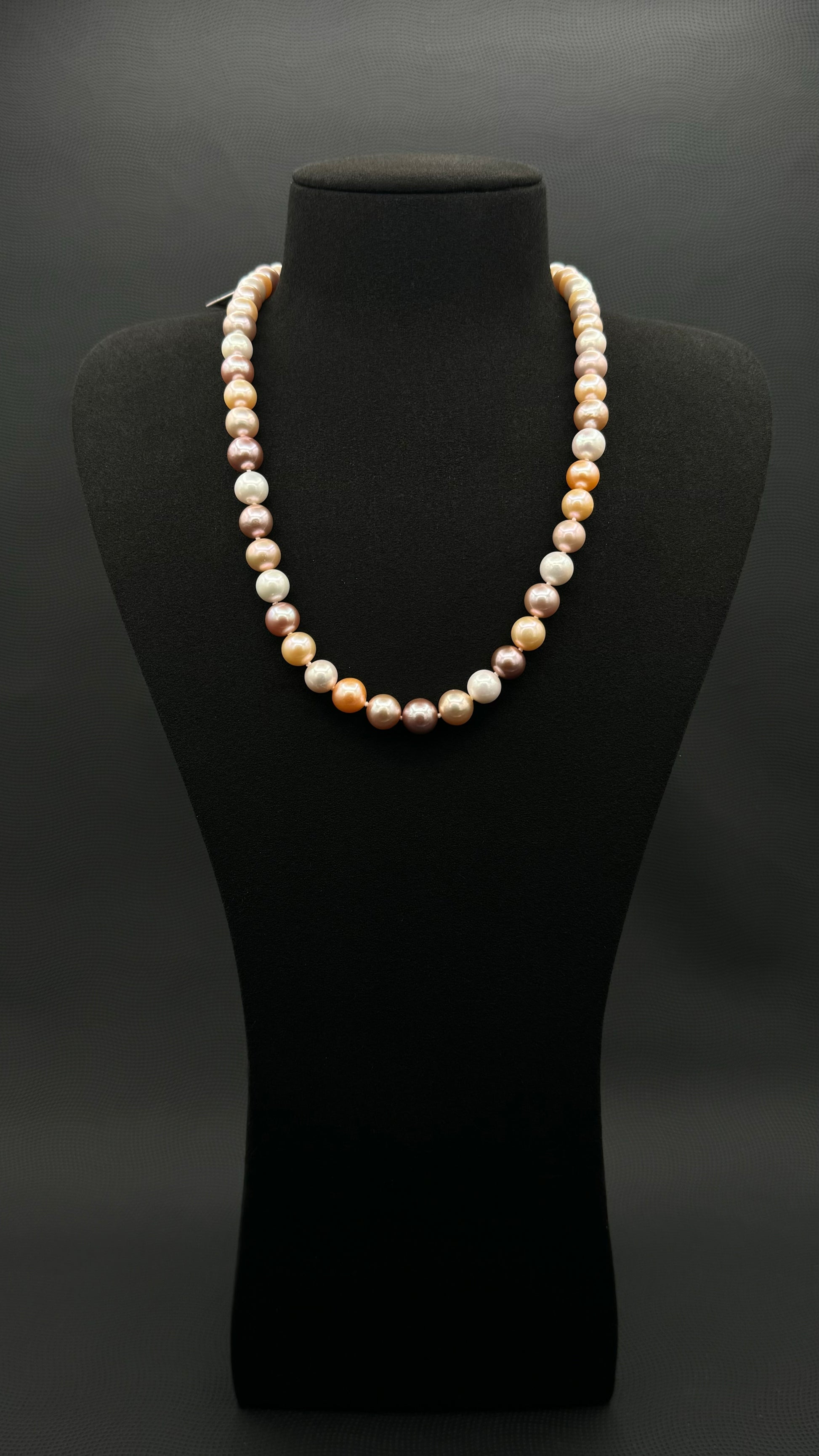 Cultured, South Sea mixed pink pearl strand necklace, exhibited on black suede, excellent reflection, 8-10mm, 20", yellow gold clasp.