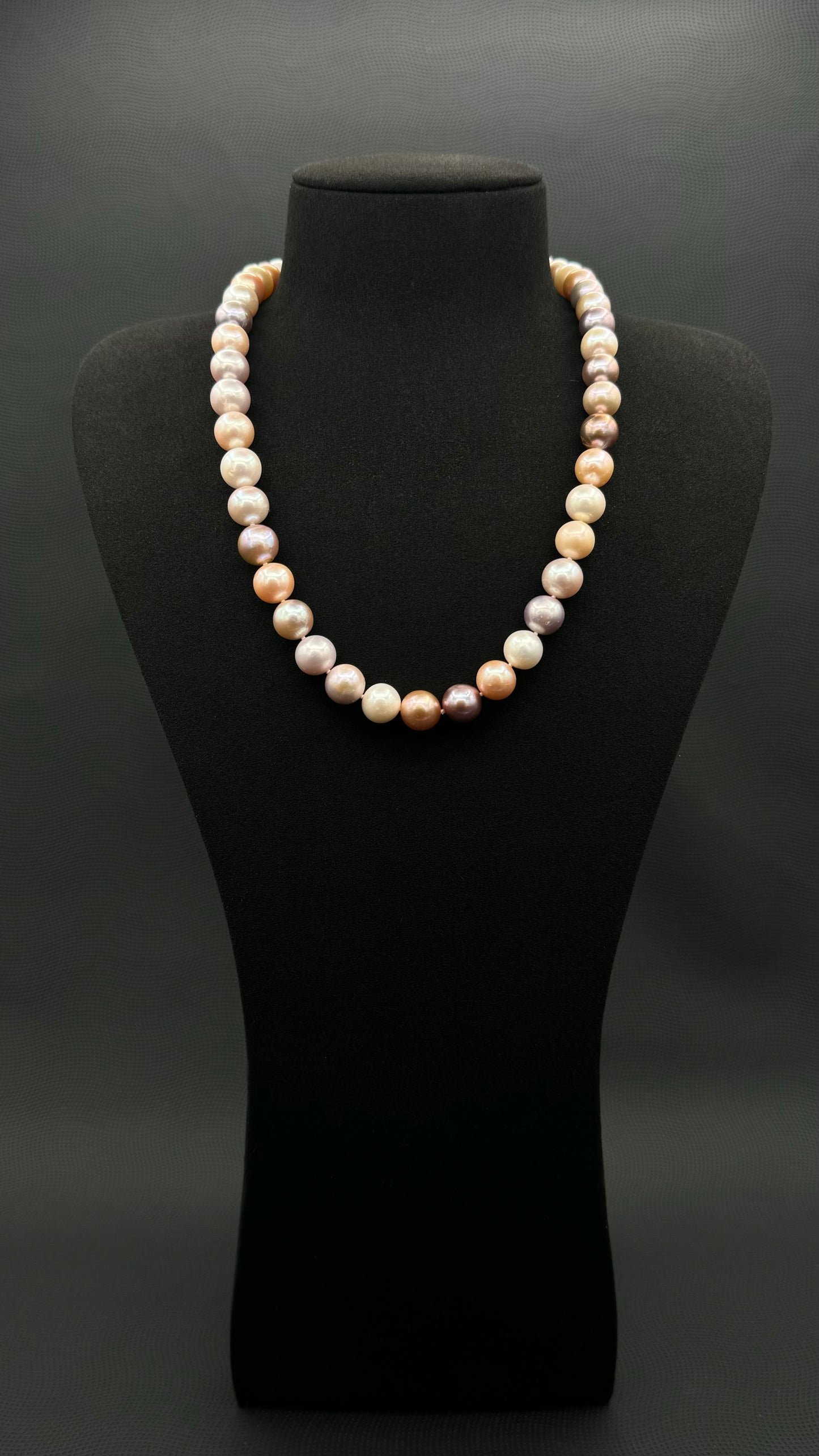 Cultured, South Sea mixed pink pearl strand necklace, exhibited on black suede, excellent reflection, 10.5mm, 20", yellow gold clasp.
