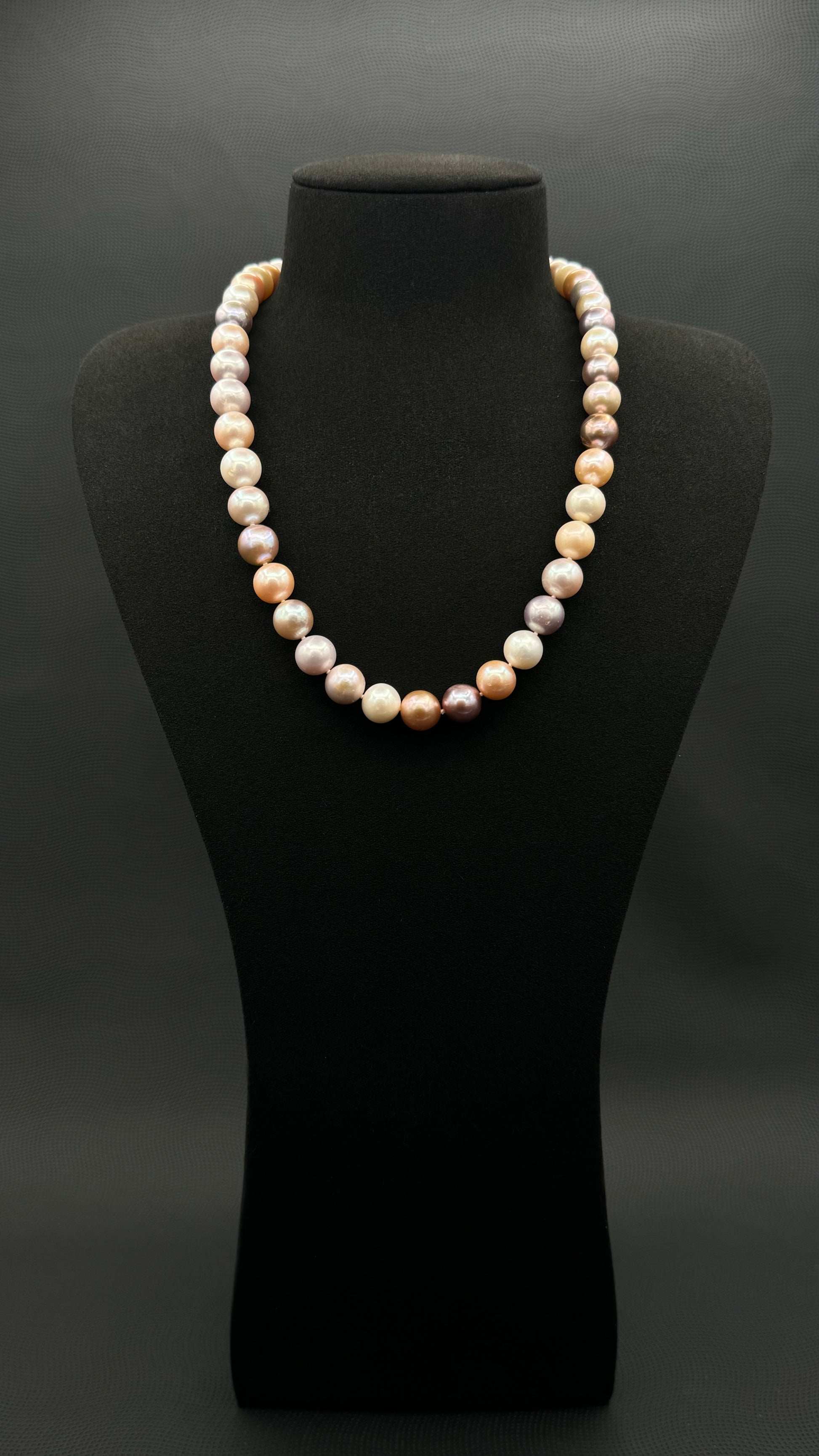Cultured, South Sea mixed pink pearl strand necklace, exhibited on black suede, excellent reflection, 10.5mm, 20", yellow gold clasp.