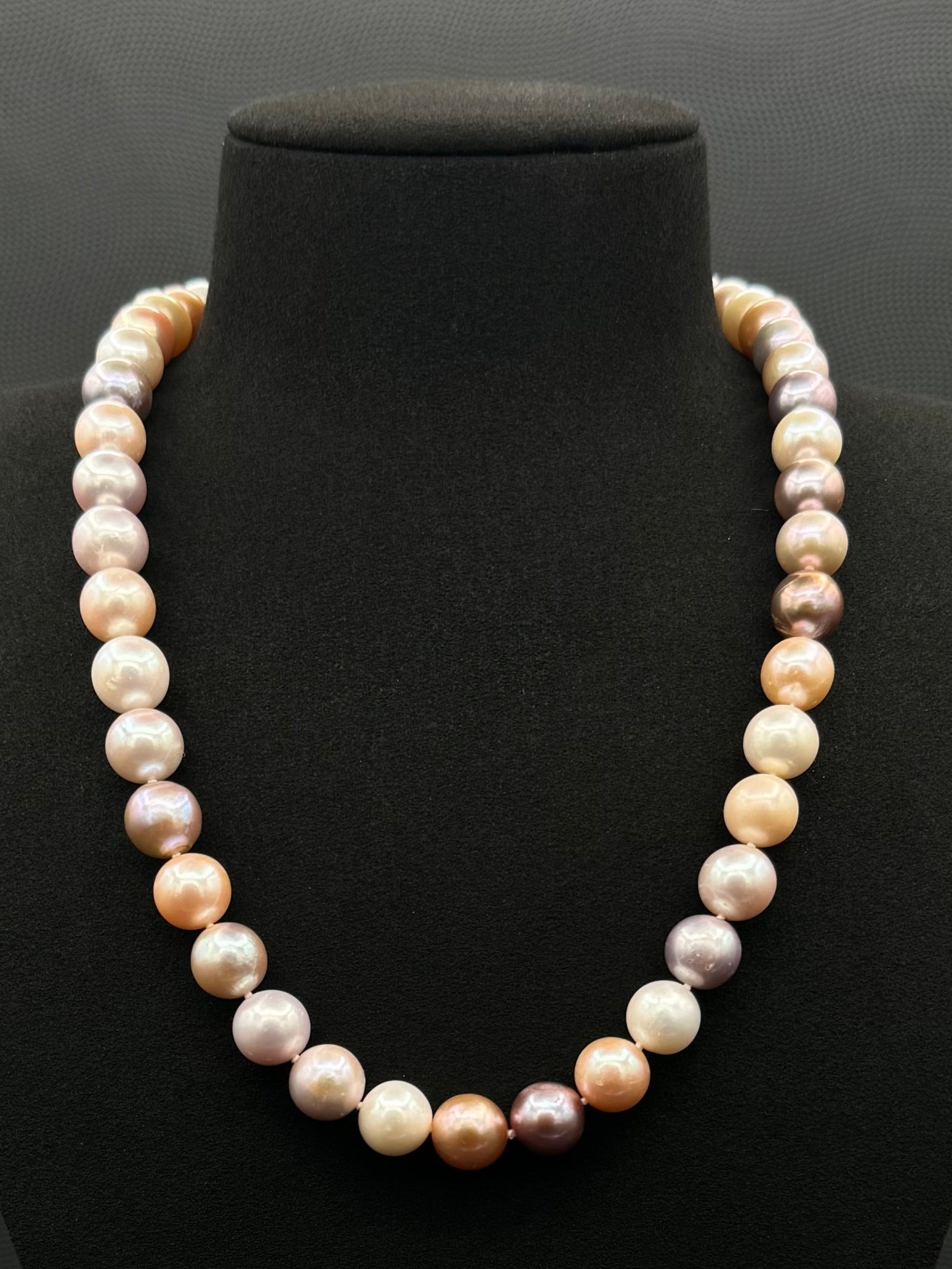 Cultured, South Sea mixed pink pearl strand necklace, exhibited on black suede, excellent reflection, 10.5mm, 20", yellow gold clasp.