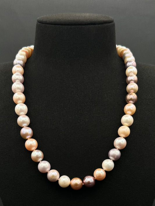 Cultured, South Sea mixed pink pearl strand necklace, exhibited on black suede, excellent reflection, 10.5mm, 20", yellow gold clasp.