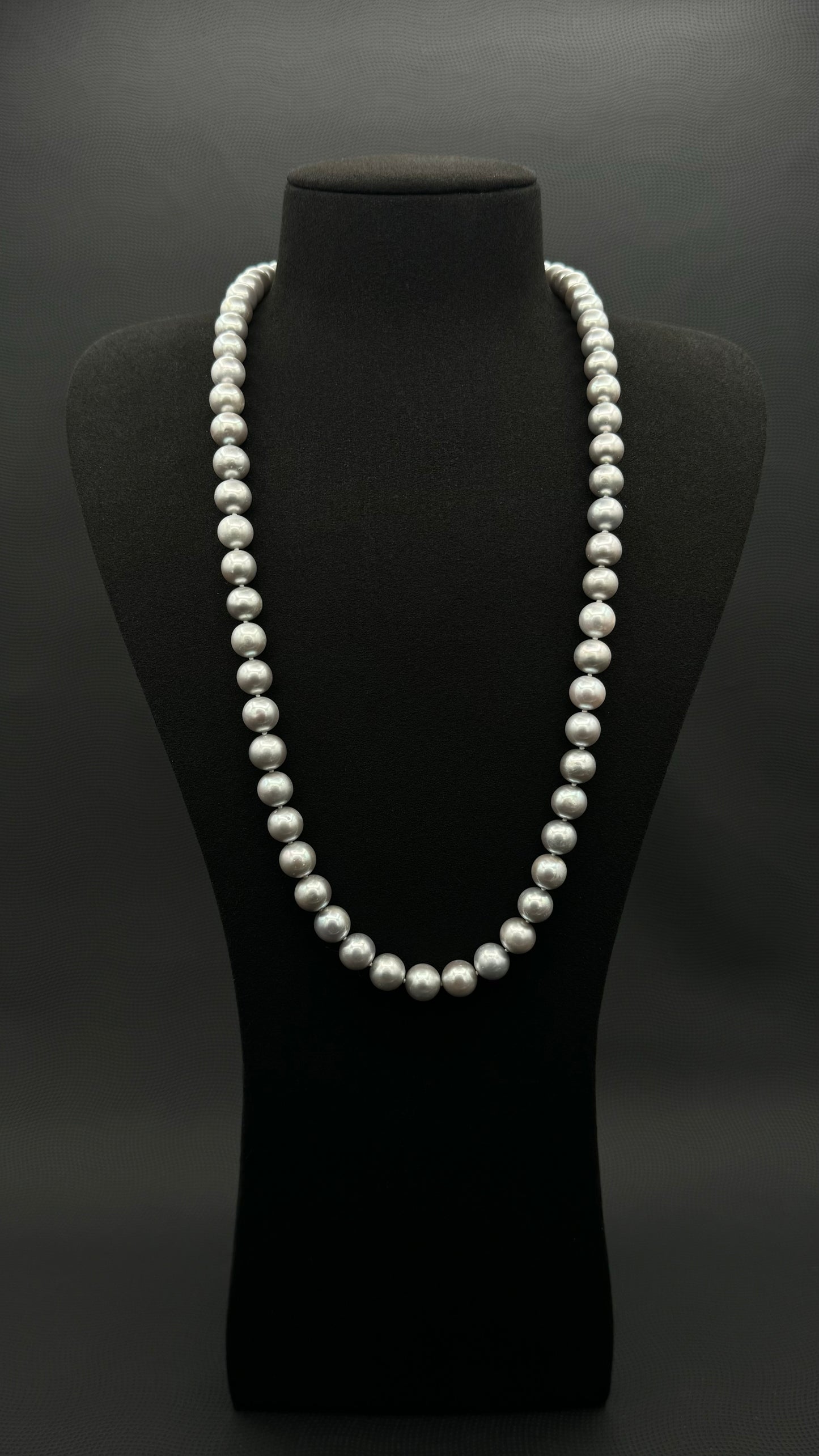 Cultured, South Sea, soft grey continuous strand pearl necklace, exhibited on black suede, excellent reflection, 9.5-10.5mm, 26", no clasp.
