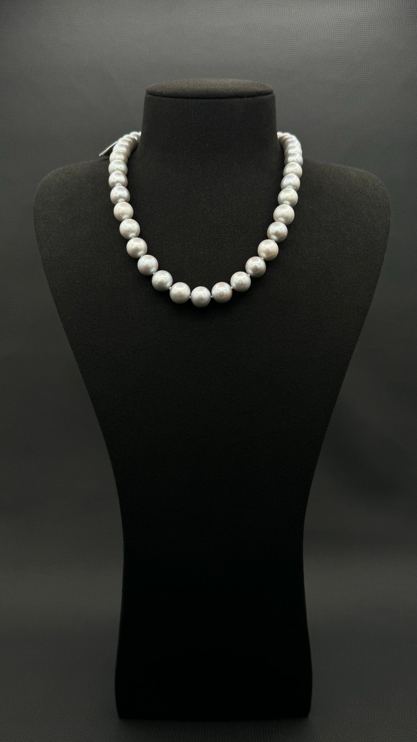 Cultured, South Sea soft grey pearl strand necklace, exhibited on black suede, sound reflection, 10.5-11mm, 18", white gold clasp.