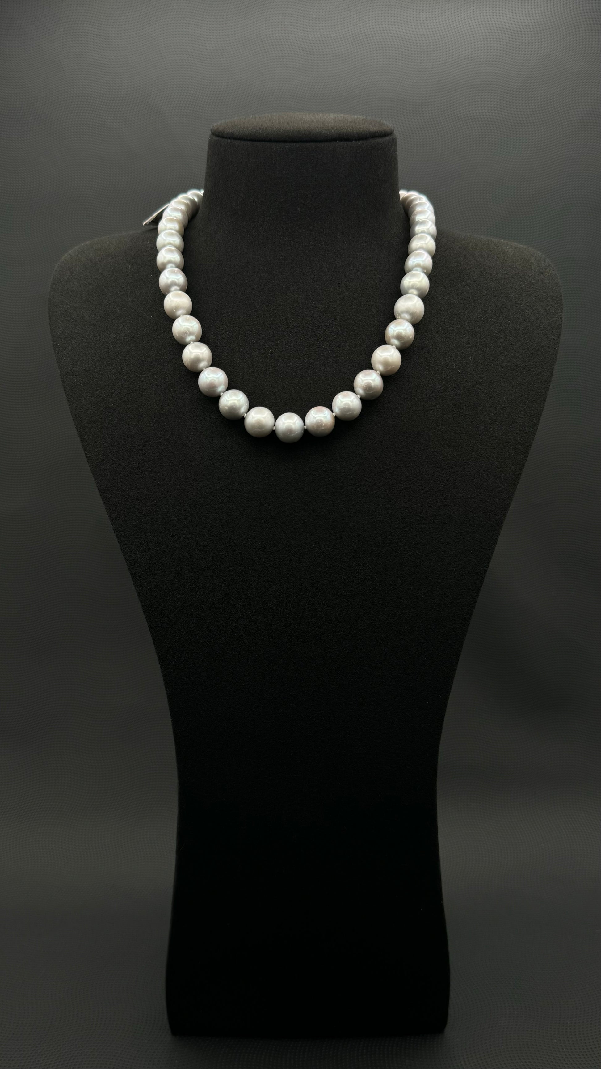 Cultured, South Sea soft grey pearl strand necklace, exhibited on black suede, sound reflection, 10.5-11mm, 18", white gold clasp.