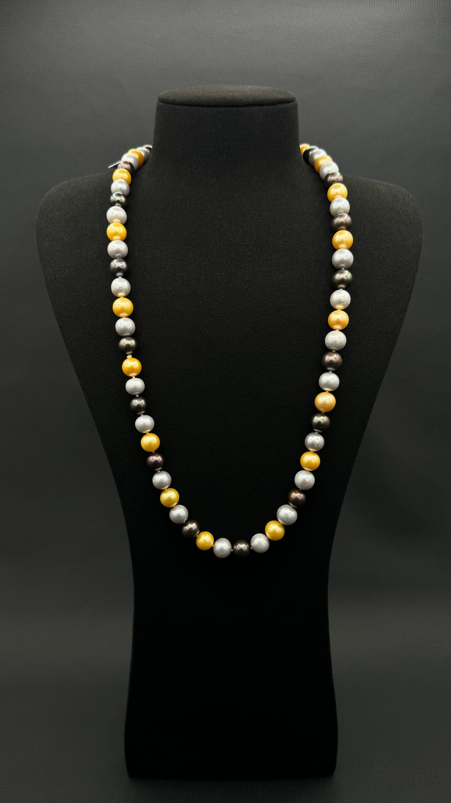 Cultured, South Sea mixed gold-grey-white continuous strand pearl necklace, exhibited on black suede, excellent reflection, 10mm, 26", no clasp.