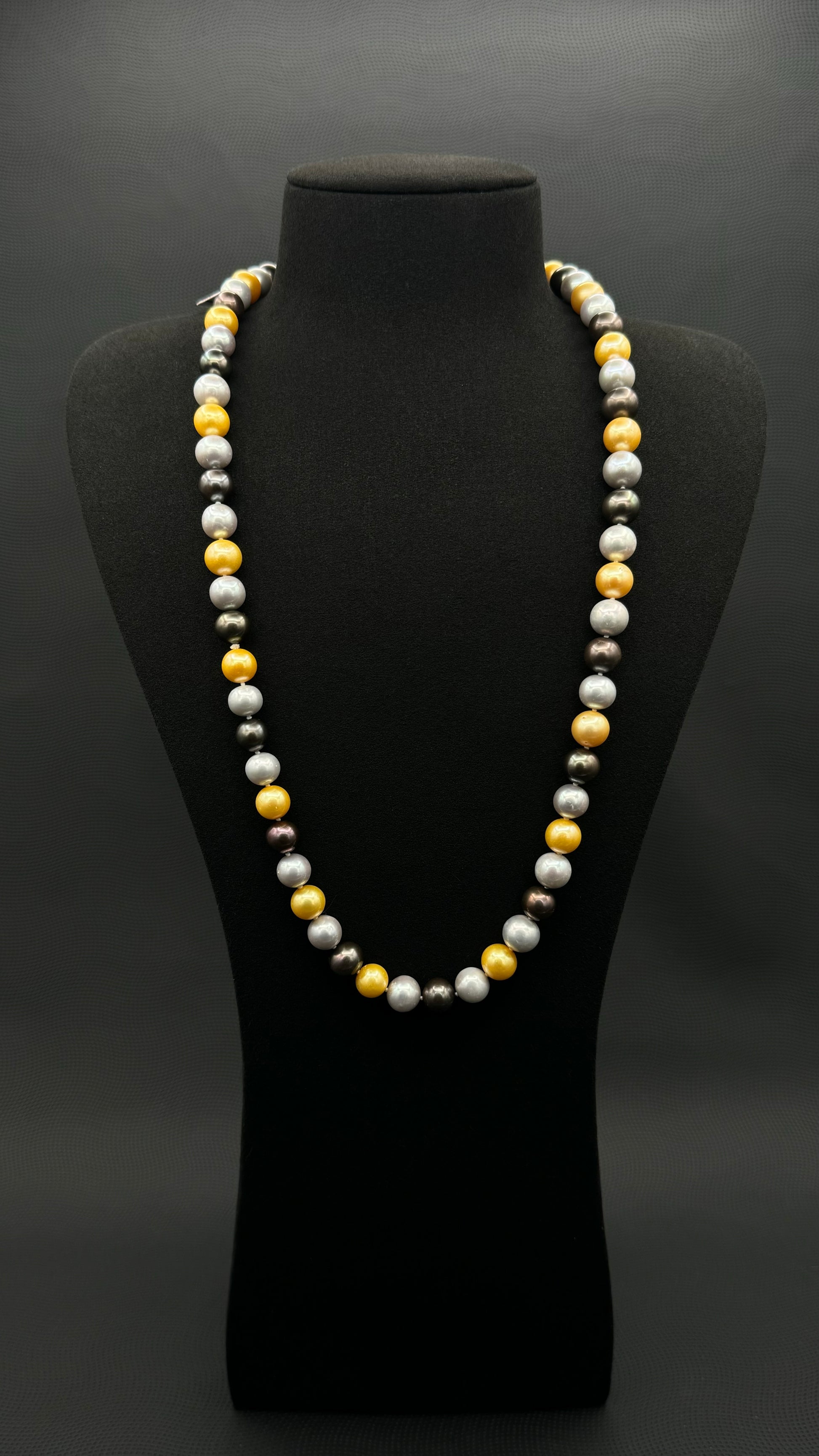 Cultured, South Sea mixed gold-grey-white continuous strand pearl necklace, exhibited on black suede, excellent reflection, 10mm, 26", no clasp.