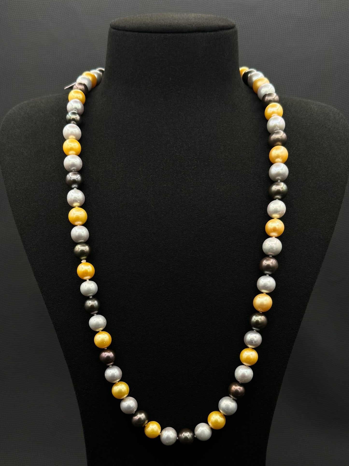 Cultured, South Sea mixed gold-grey-white continuous strand pearl necklace, exhibited on black suede, excellent reflection, 10mm, 26", no clasp.