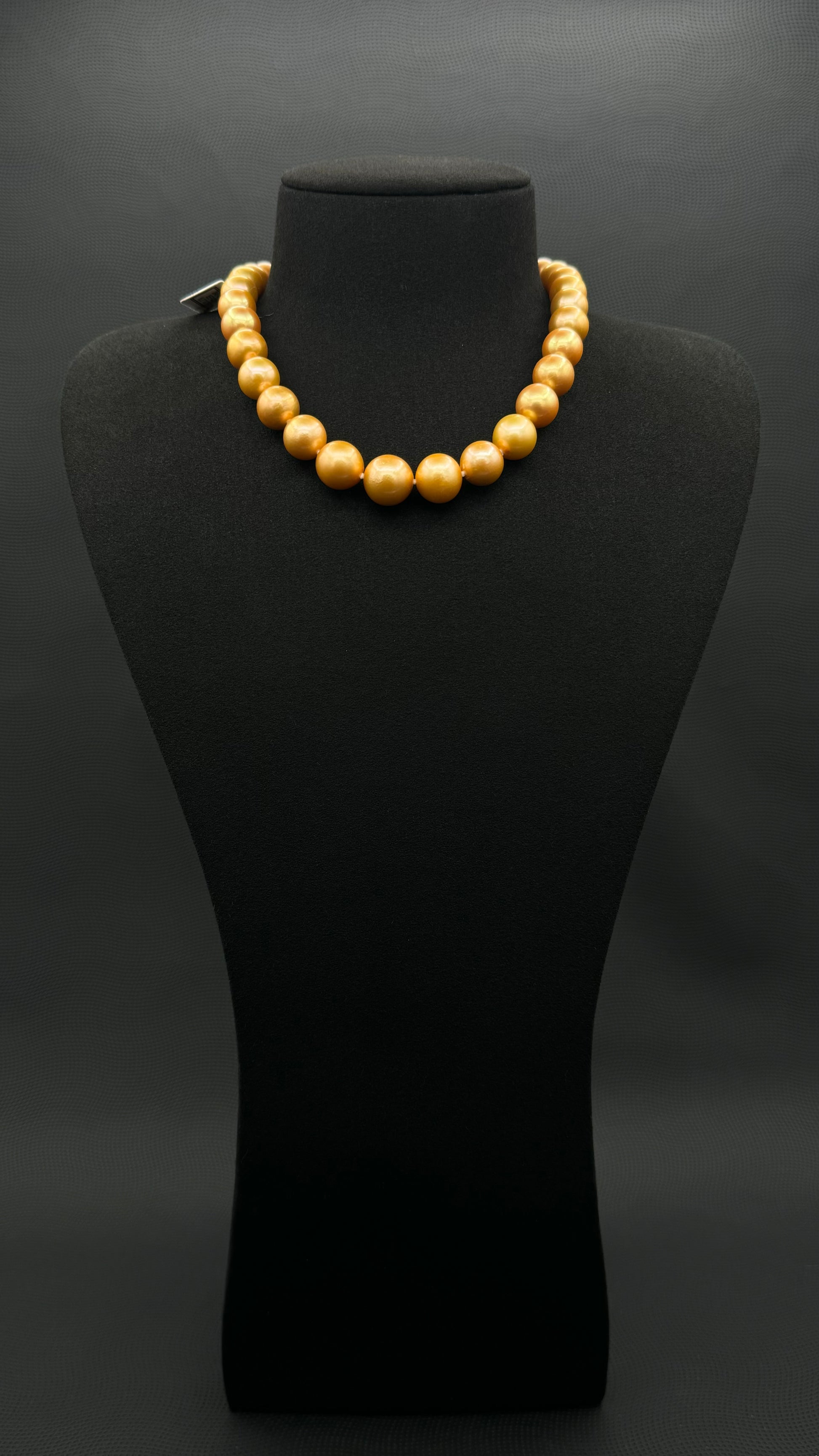 Cultured, South Sea, deep gold pearl necklace, exhibited on black suede, excellent reflection, 11-13.5mm, 15.5", 14k yellow gold clasp.