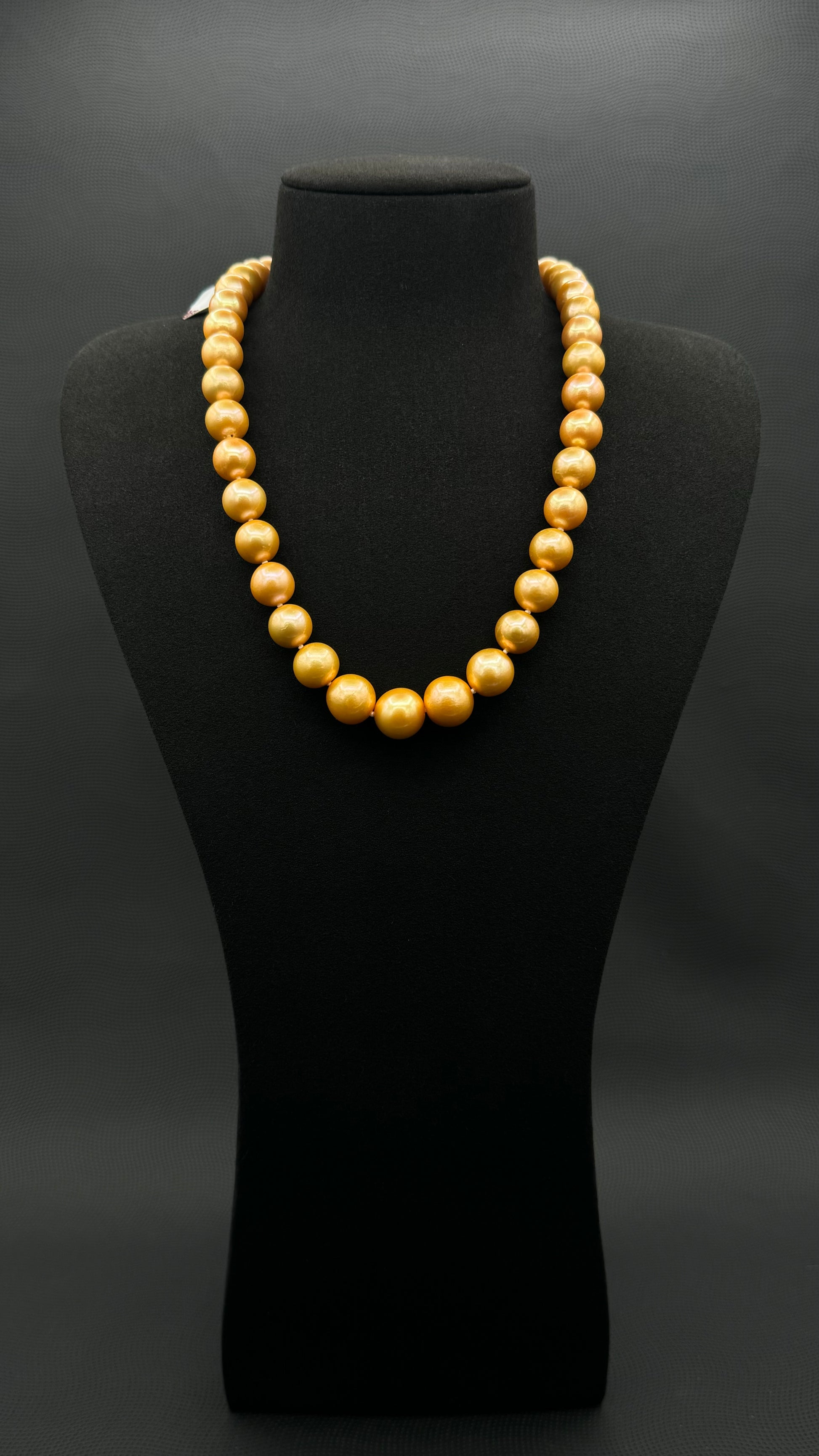 Cultured, South Sea deep-gold pearl strand necklace, exhibited on black suede, excellent reflection, 11-14mm, 20", yellow gold clasp.