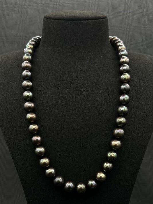 Cultured, Tahitian black-green continuous strand pearl necklace, exhibited on black suede, excellent reflection, 11.5-12.5mm, 24", no clasp.