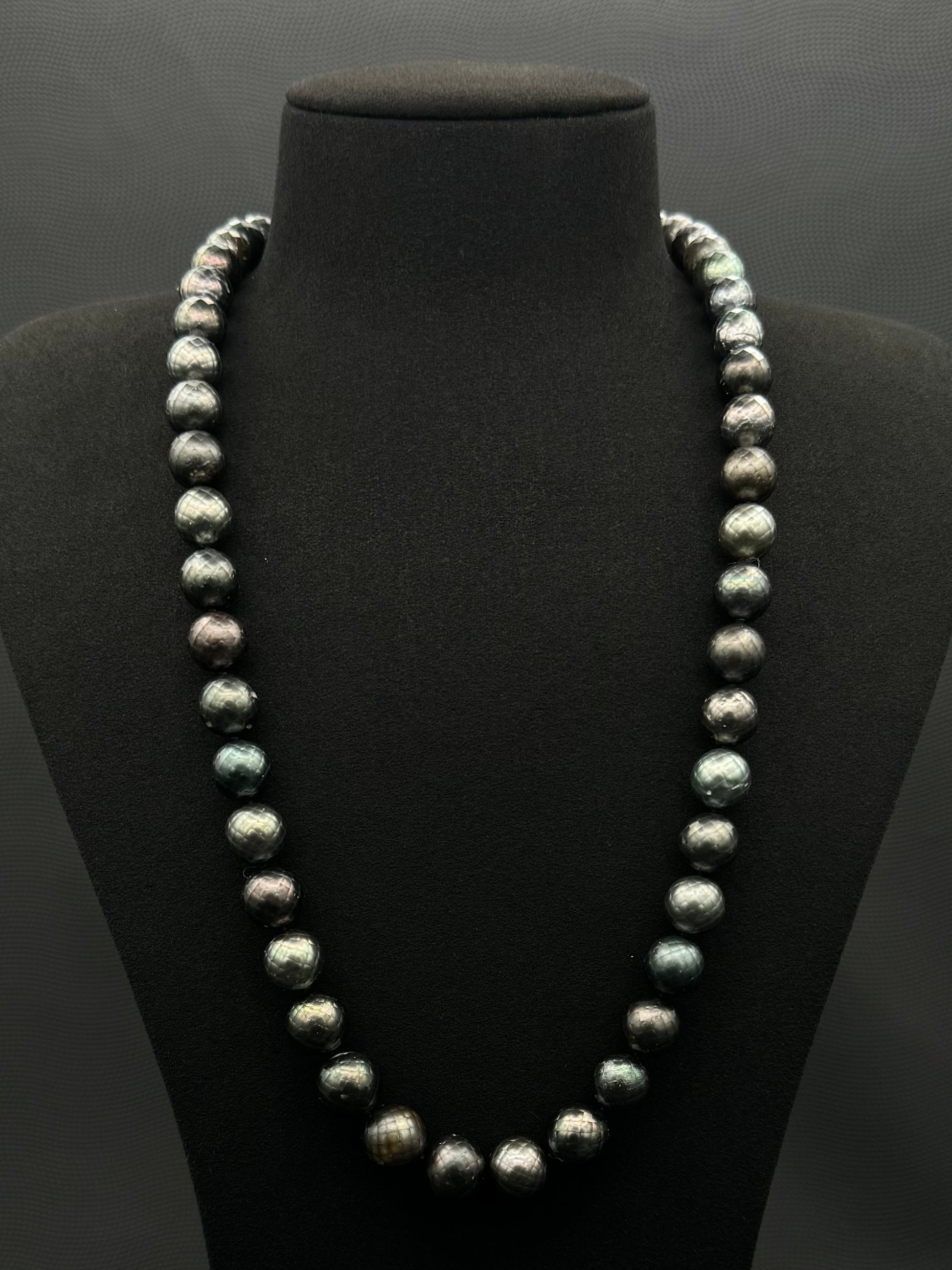 Cultured, Tahitian Carved black-green continuous strand pearl necklace, exhibited on black suede, fair to sound reflection, 10mm, 24", no clasp.