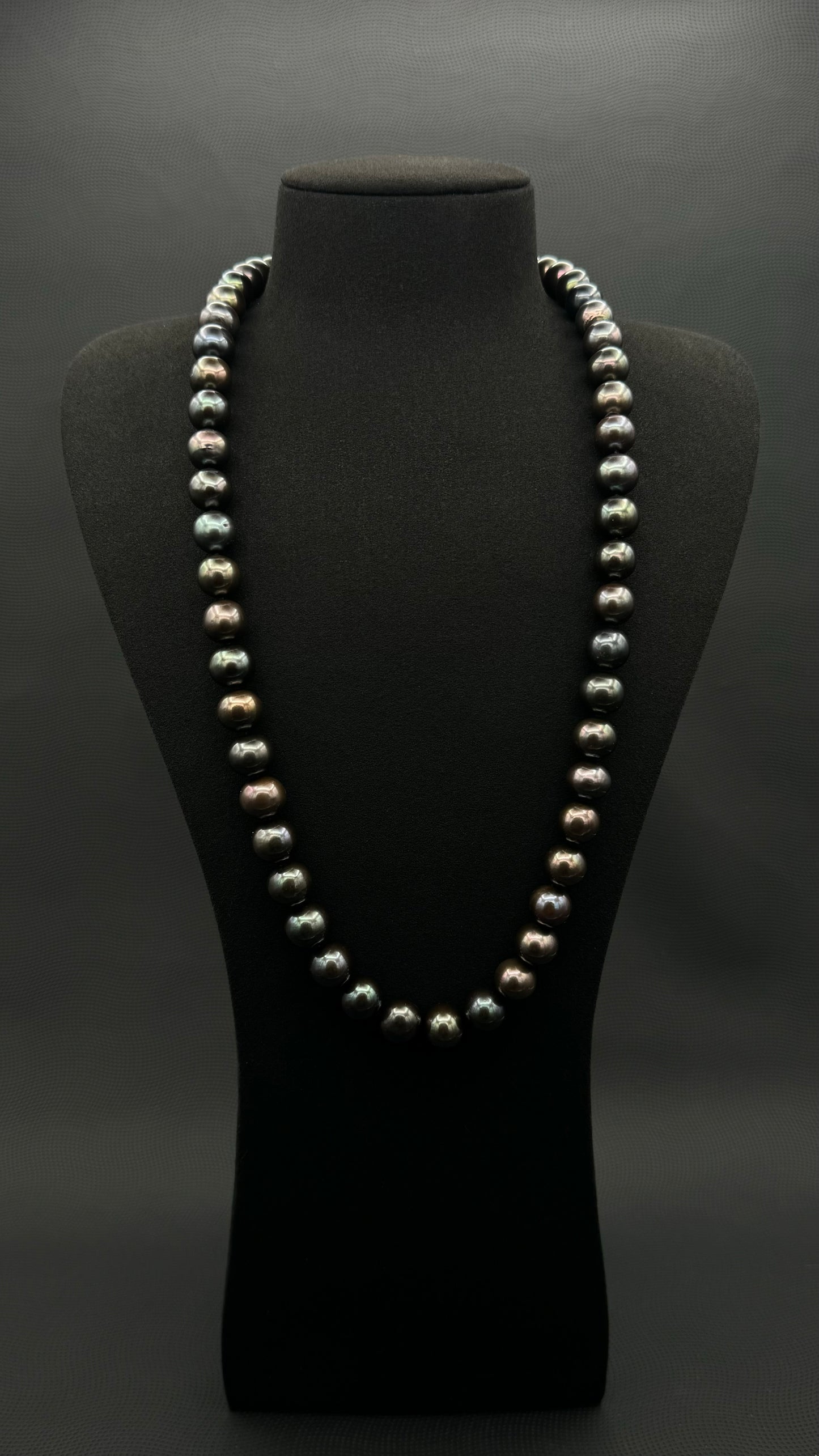 Cultured, Tahitian, black-violet-green continuous strand pearl necklace, exhibited on black suede, excellent reflection, 11-12.5mm, 26", no clasp.