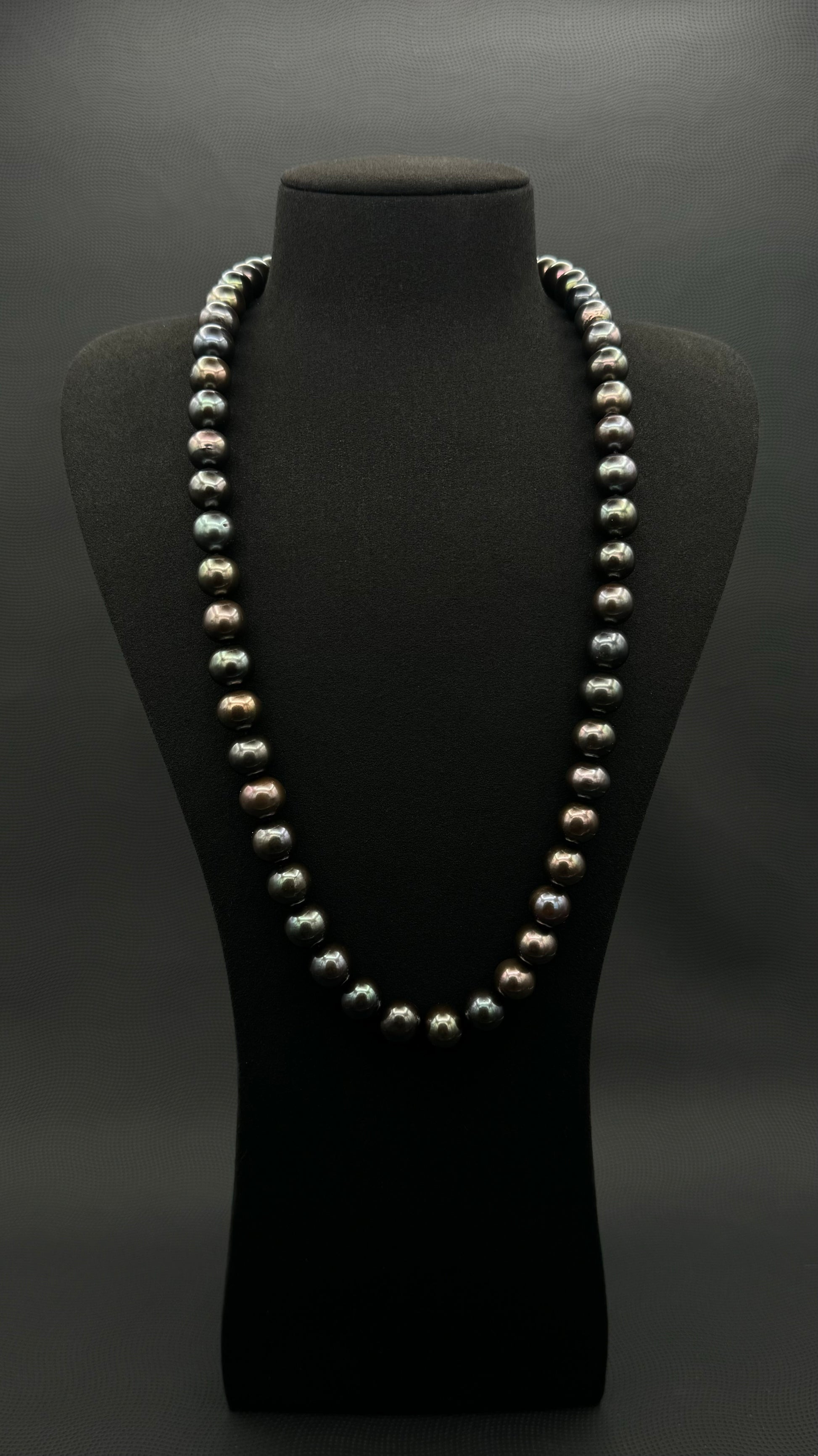 Cultured, Tahitian, black-violet-green continuous strand pearl necklace, exhibited on black suede, excellent reflection, 11-12.5mm, 26", no clasp.