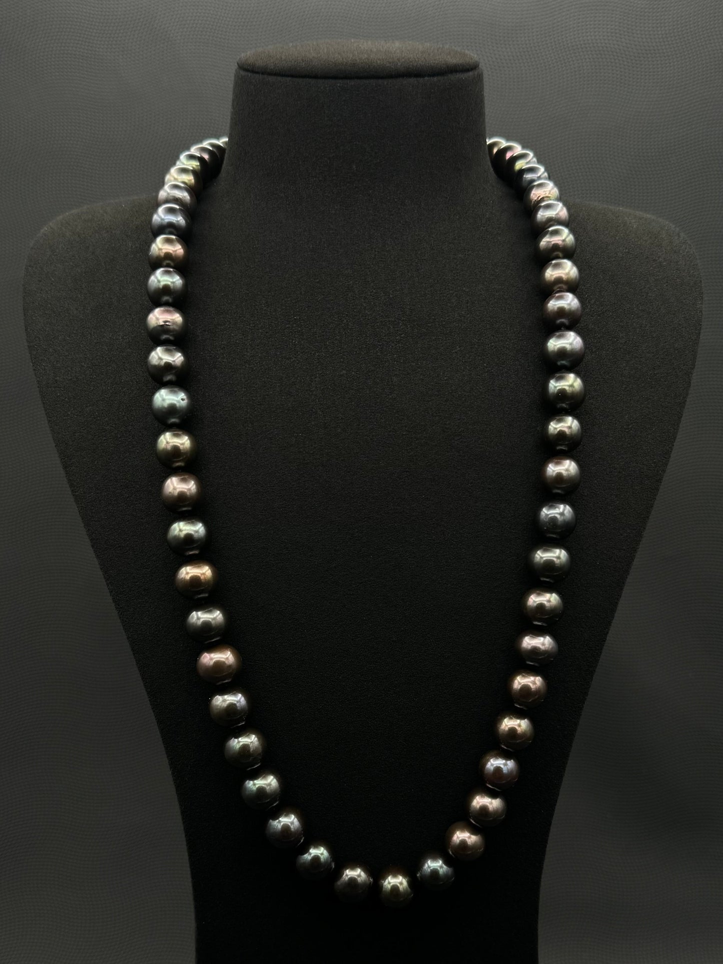 Cultured, Tahitian, black-violet-green continuous strand pearl necklace, exhibited on black suede, excellent reflection, 11-12.5mm, 26", no clasp.