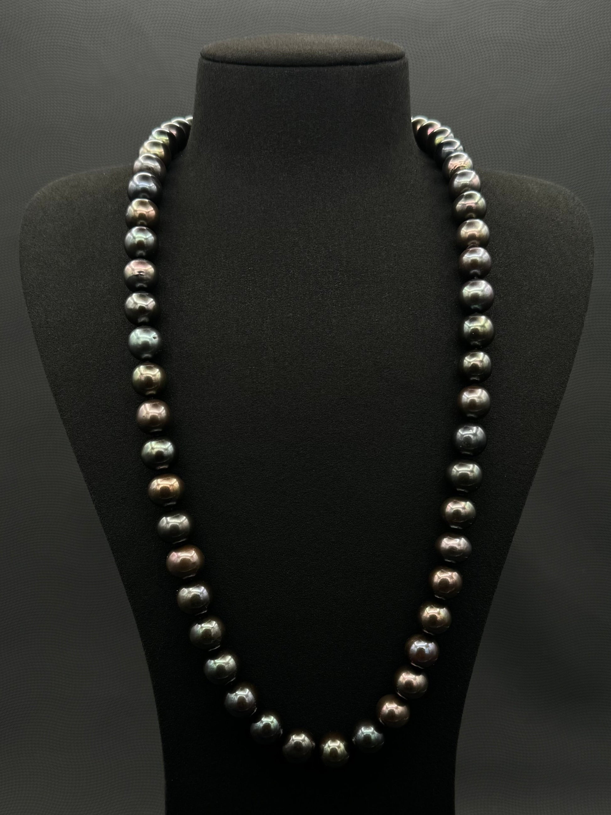 Cultured, Tahitian, black-violet-green continuous strand pearl necklace, exhibited on black suede, excellent reflection, 11-12.5mm, 26", no clasp.