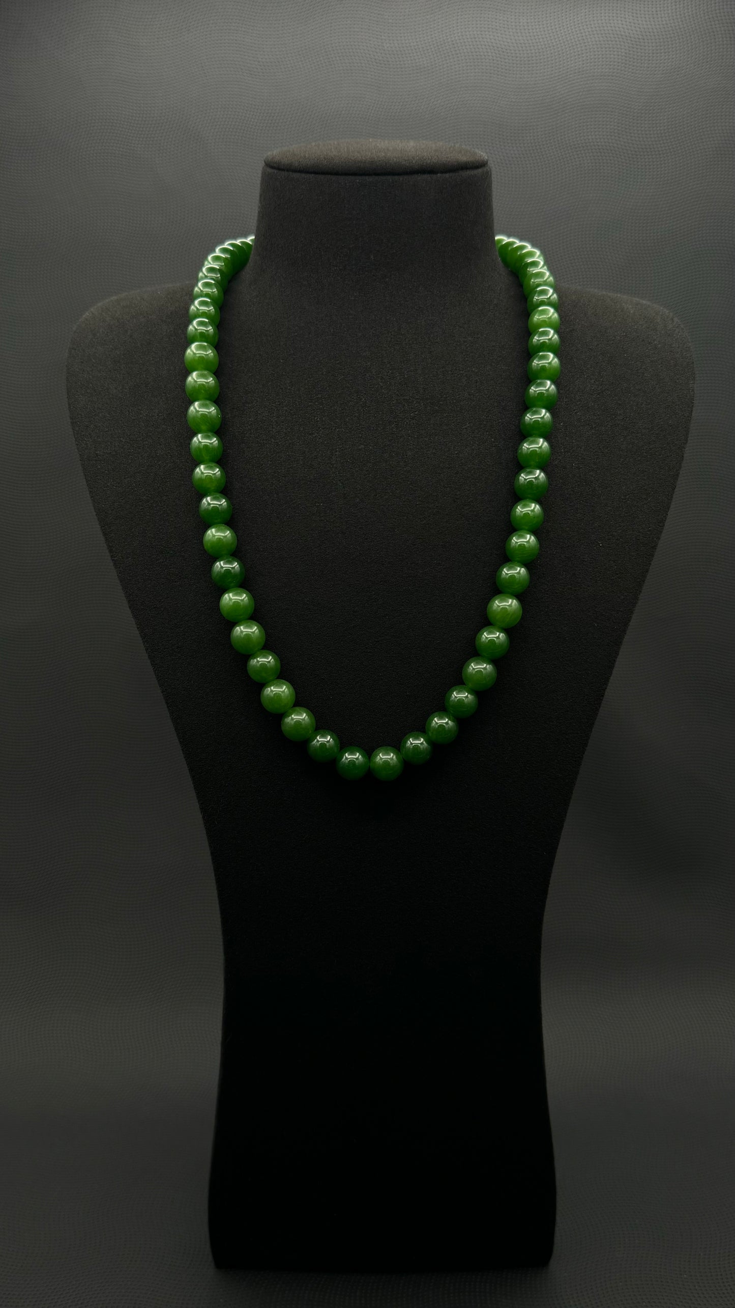 Genuine Jasper necklace, strand of continuous emerald green beads, exhibited on black suede, 10.5mm, 23"