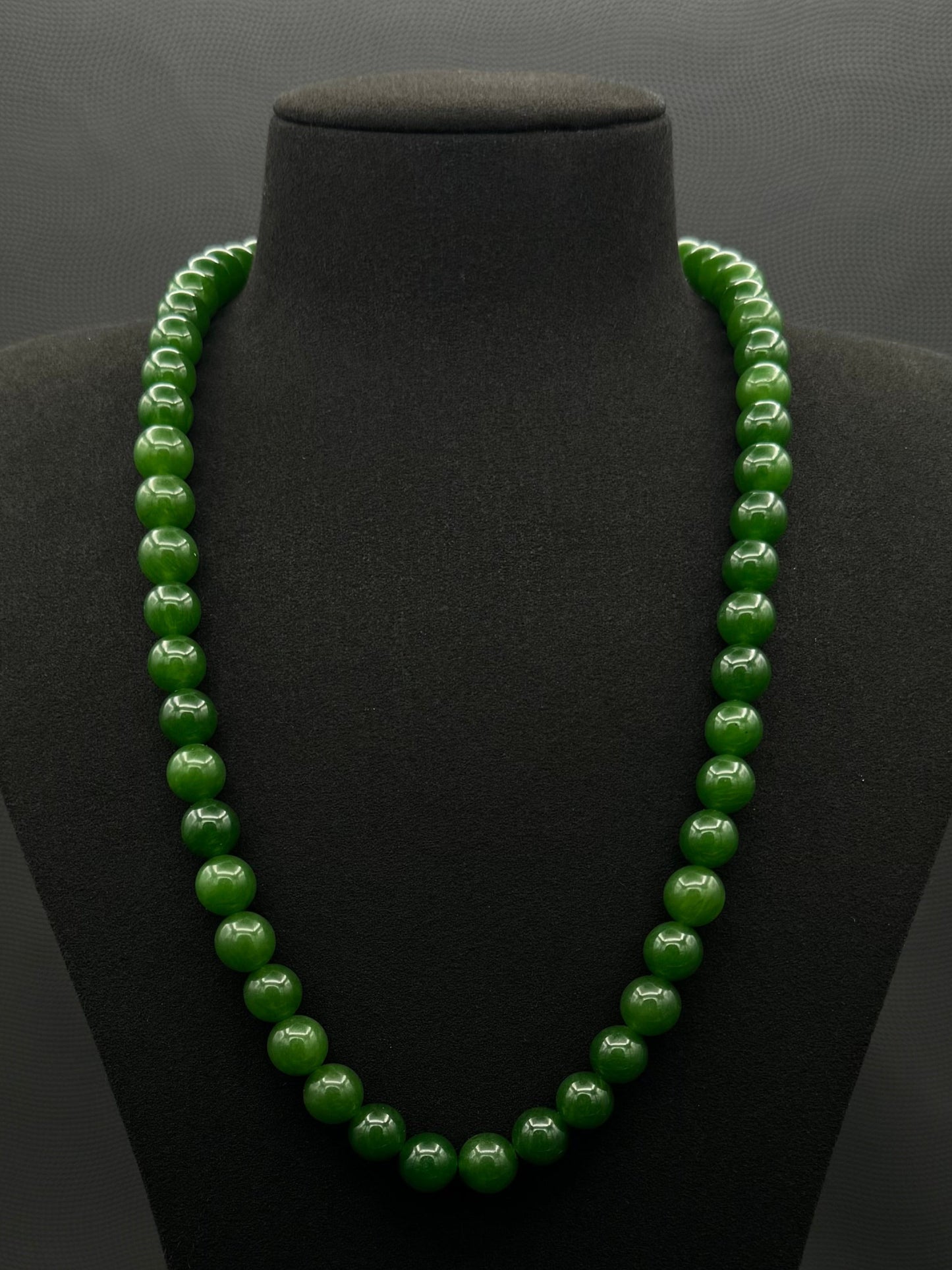 Genuine Jasper necklace, strand of continuous emerald green beads, exhibited on black suede, 10.5mm, 23"