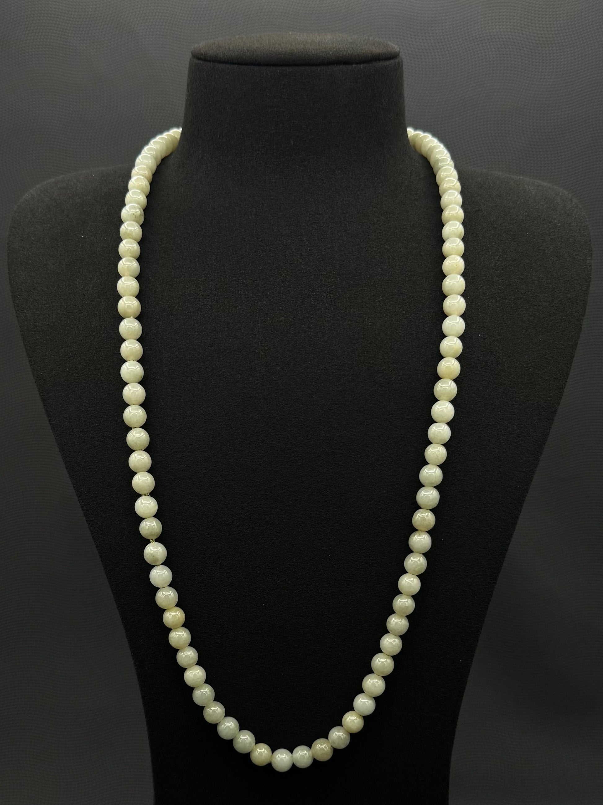 Genuine, Jade necklace, strand of continuous light green beads, exhibited on black suede, 7.5mm, 27"