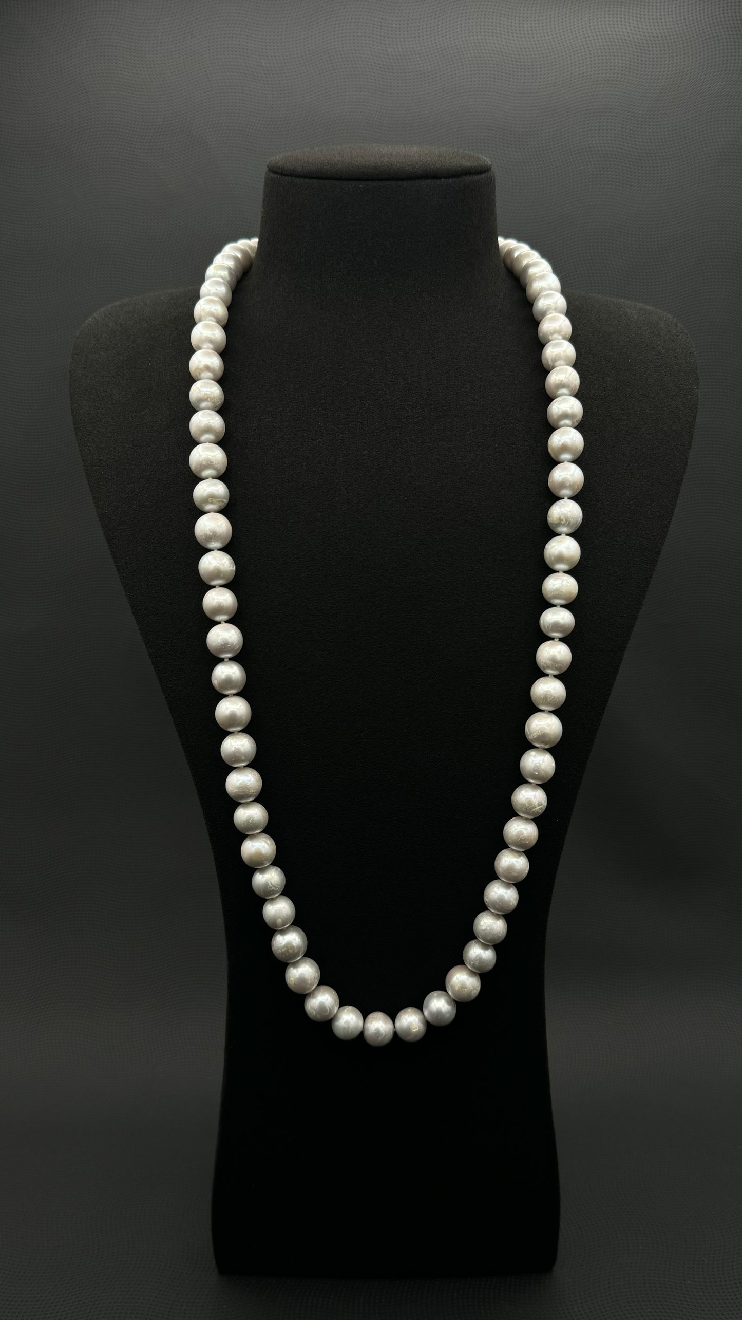 Cultured, South Sea, soft grey continuous strand pearl necklace, exhibited on black suede, fair reflection, 10-11mm, 30", no clasp.