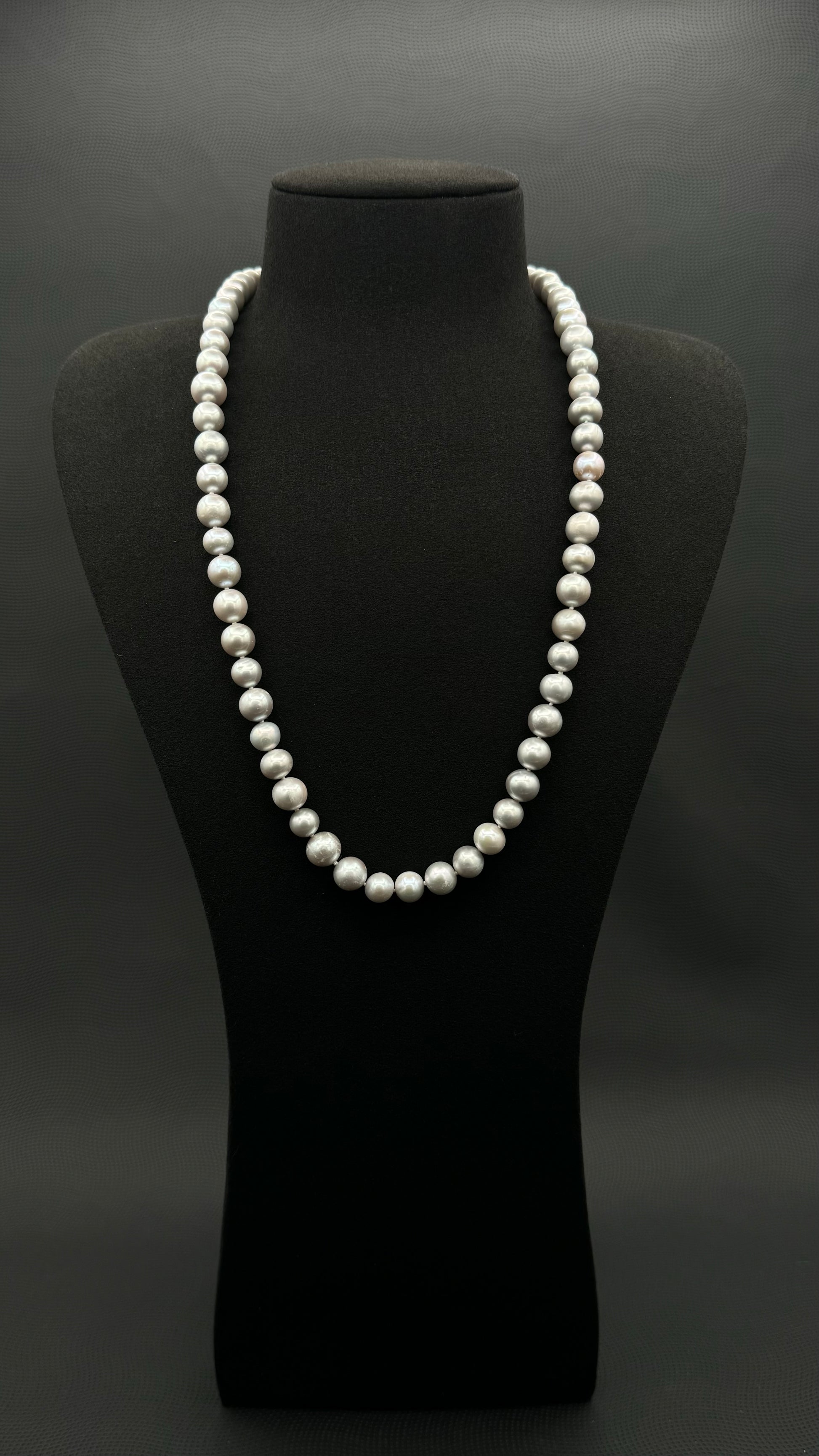 Cultured, South Sea soft grey pearl continuous strand necklace, exhibited on black suede, fair reflection, 9-10mm, 24", no clasp.