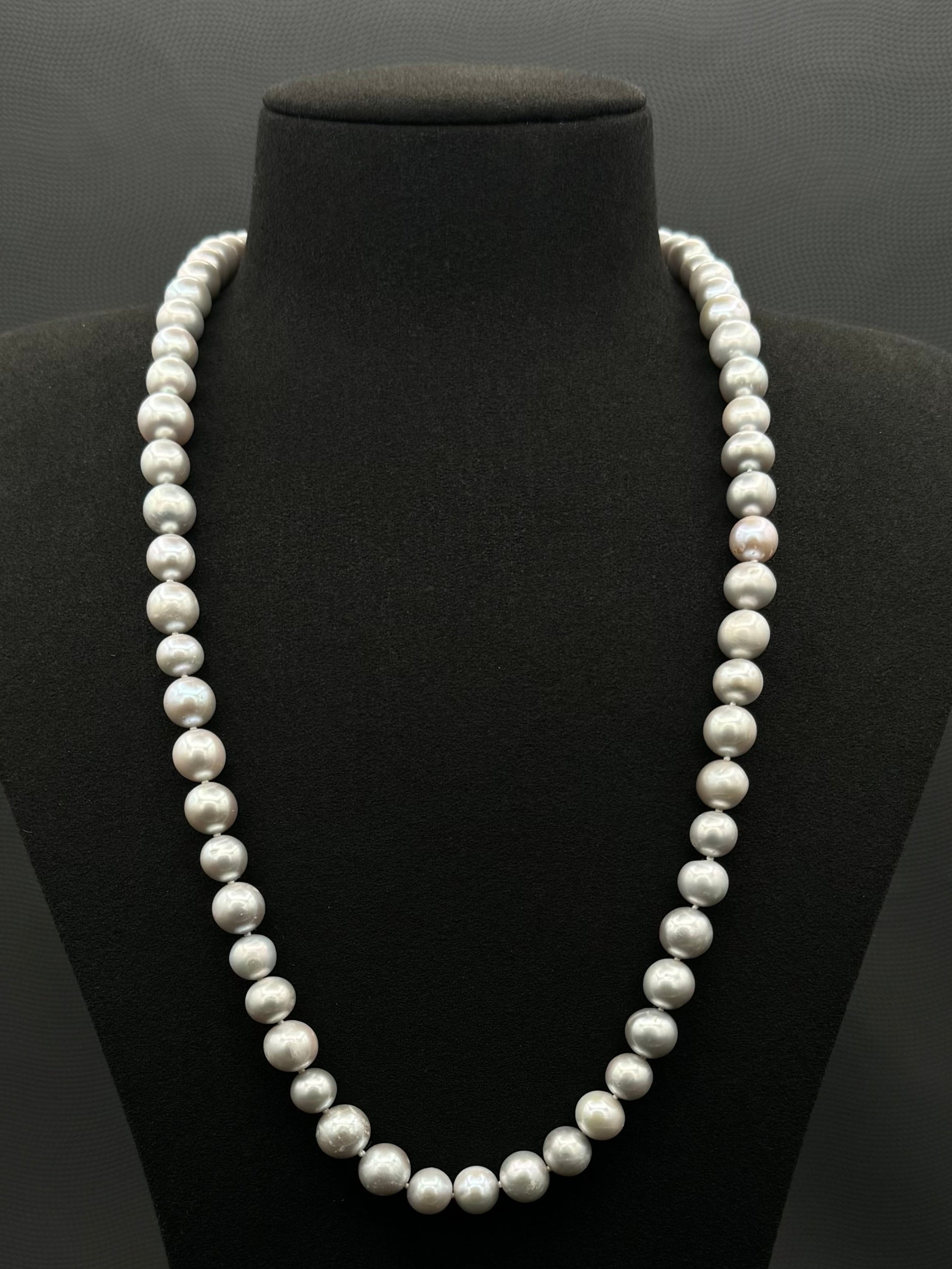 Cultured, South Sea soft grey pearl continuous strand necklace, exhibited on black suede, fair reflection, 9-10mm, 24", no clasp.