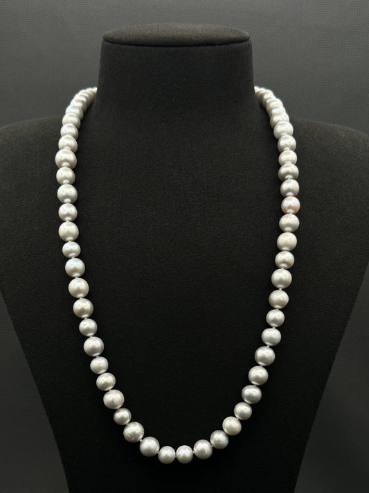 Cultured, South Sea, soft grey continuous strand pearl necklace, exhibited on black suede, fair reflection, 10-11mm, 30", no clasp.