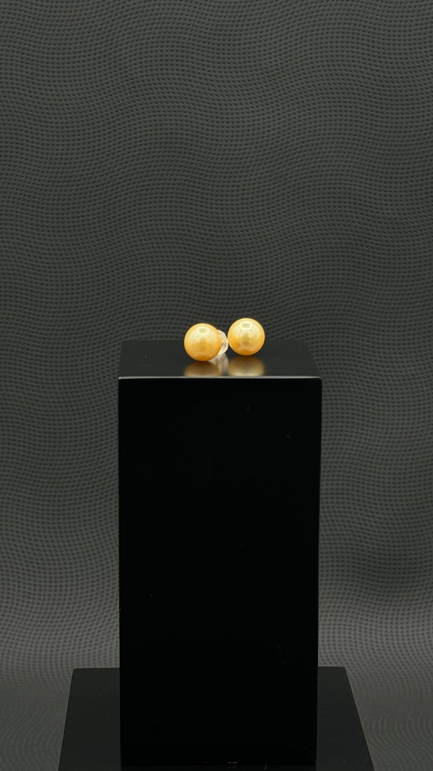 Cultured, South Sea, pearl earrings, exhibited on black box, golden, stud style, fairly sharp, 9.5mm, 18k yellow gold.