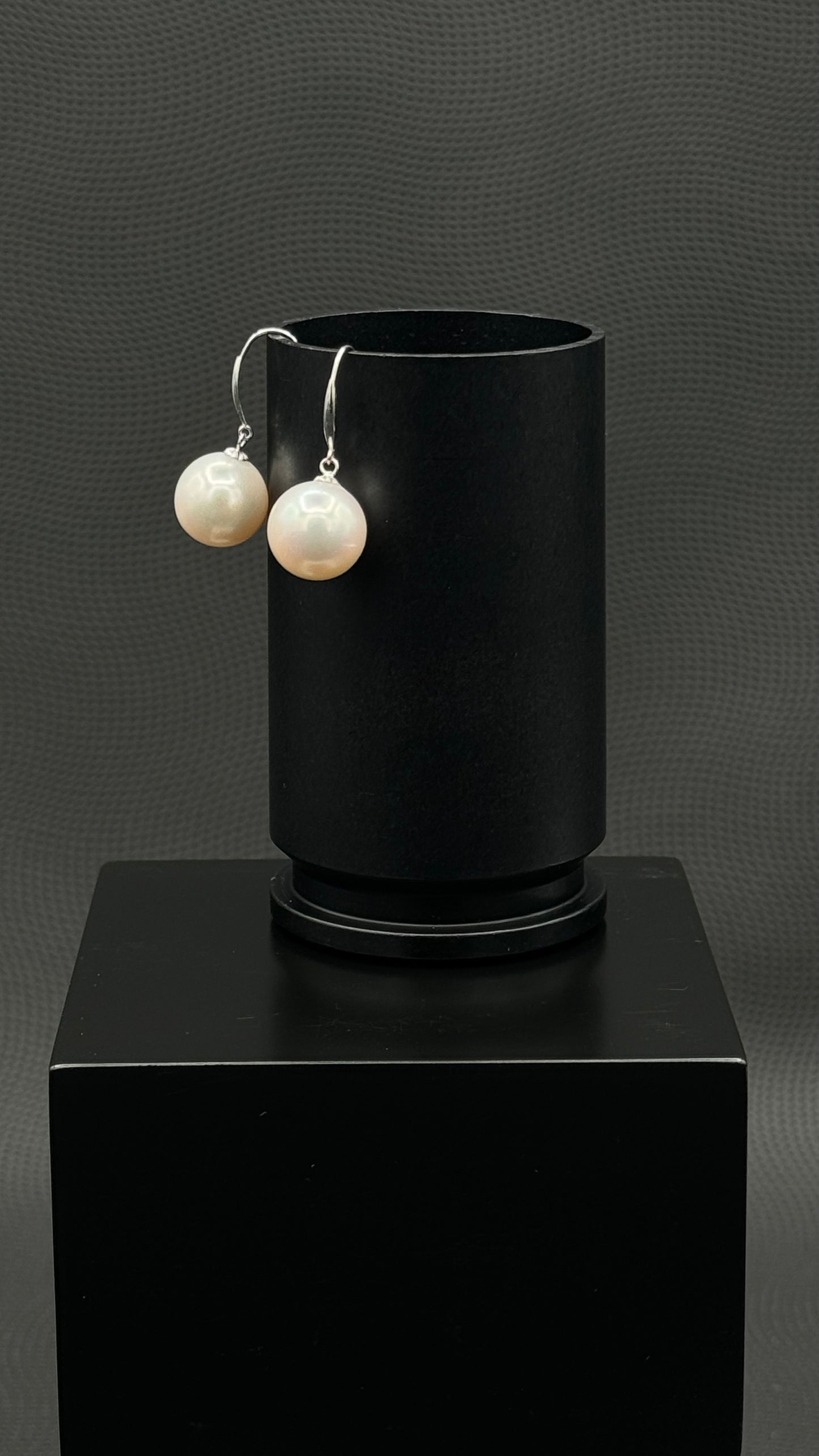 Cultured, South Sea, pearl earrings, exhibited on black box, white, drop style, sound reflection, 11-12mm, 18k yellow gold.