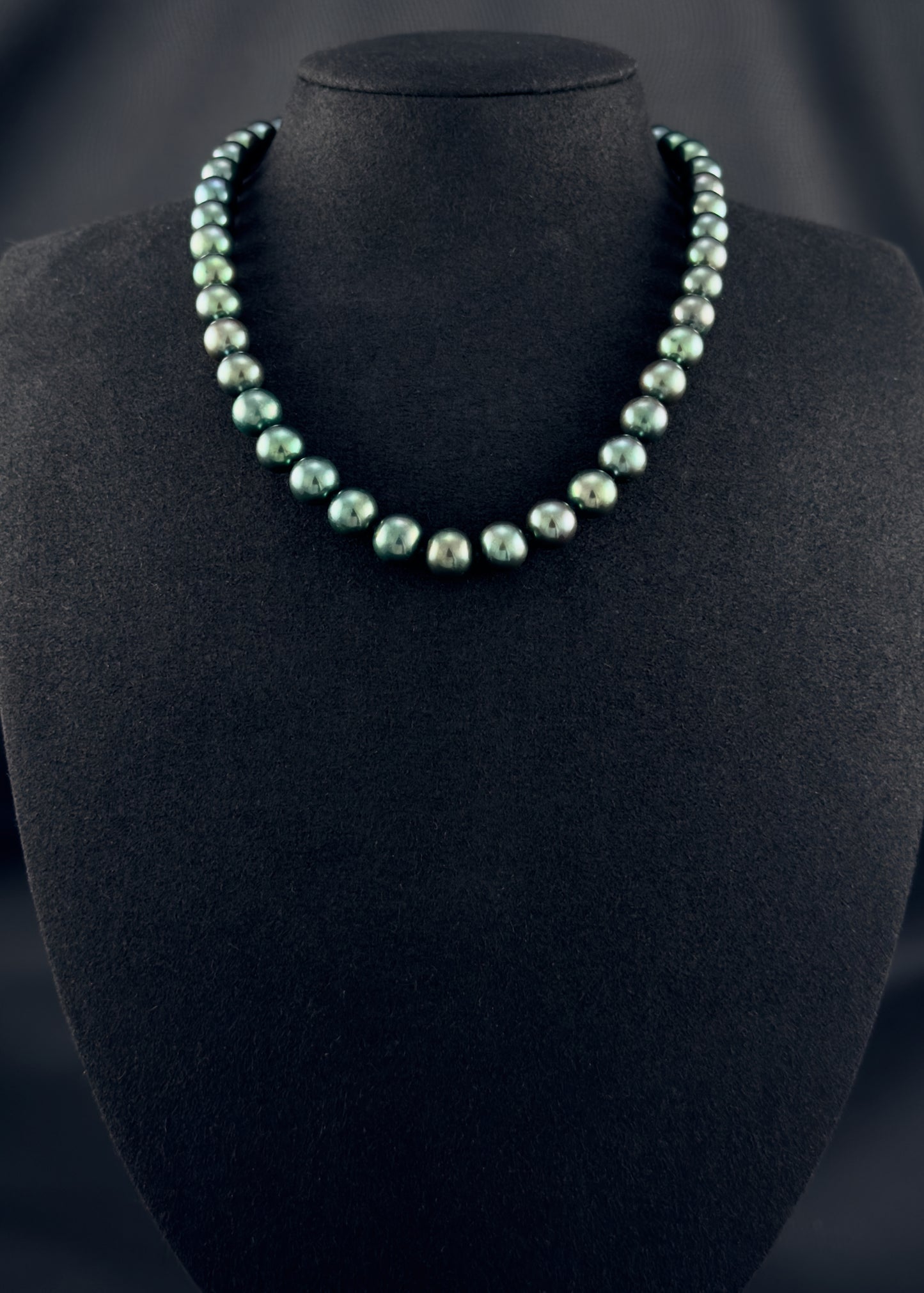 Cultured, Tahitian, green pearl strand necklace, exhibited on black suede, sound reflection, 9-9.5mm, 16", yellow gold clasp.