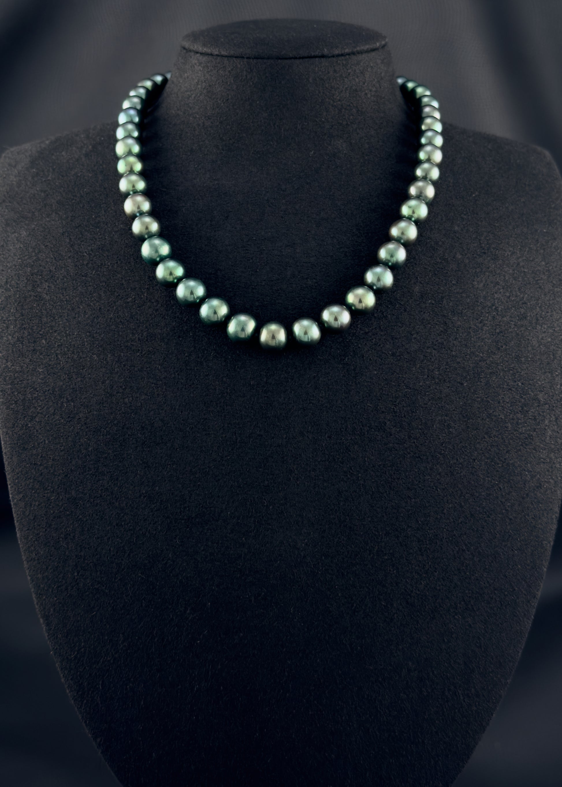 Cultured, Tahitian, green pearl strand necklace, exhibited on black suede, sound reflection, 9-9.5mm, 16", yellow gold clasp.