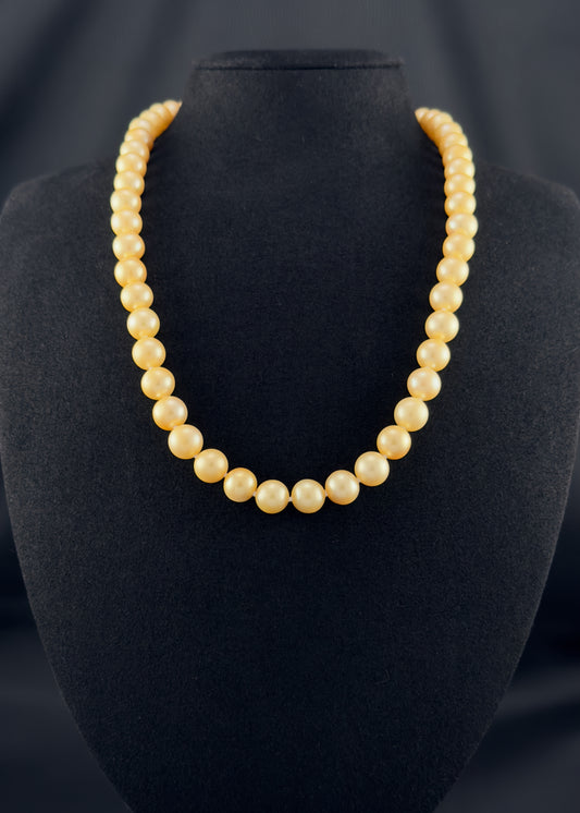 Cultured, South Sea golden pearl necklace, exhibited on black suede, fair to sound reflection, 8.5-10mm, 20", yellow gold clasp.