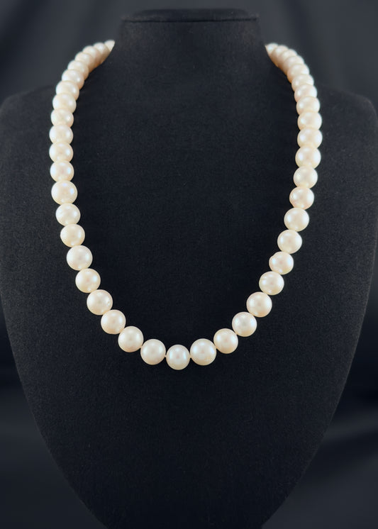 Cultured, South Sea, white pearl continuous strand necklace, exhibited on black suede, fair reflection, 10-11mm, 21.5", no clasp.