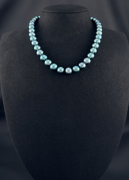 Cultured, Tahitian, green-blue pearl strand necklace, exhibited on black suede, sound reflection, 11-12mm, 16", yellow gold clasp.